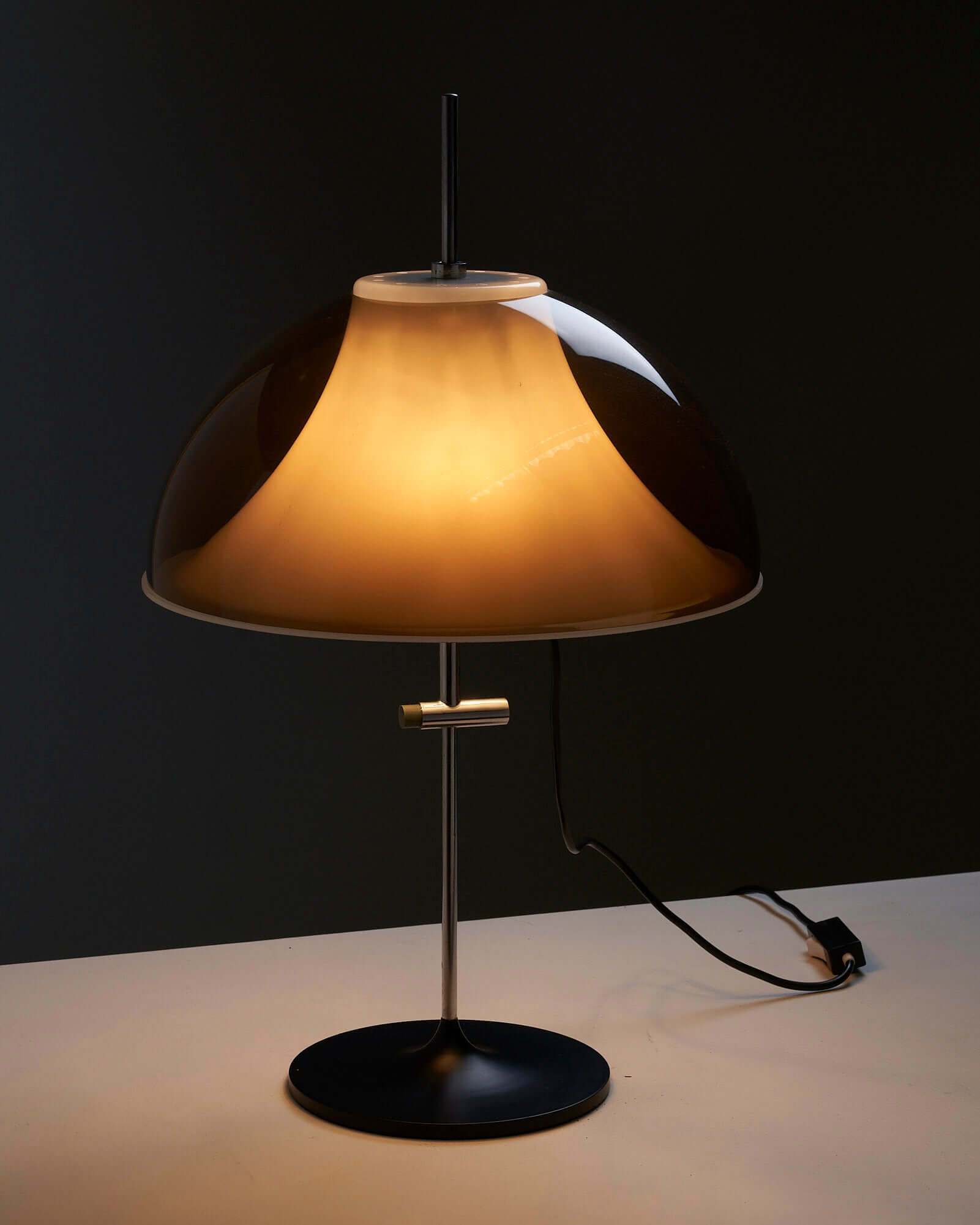 Modern chic table lamp with a curved shade, emitting warm light, enhancing interior decor with stylish functionality.