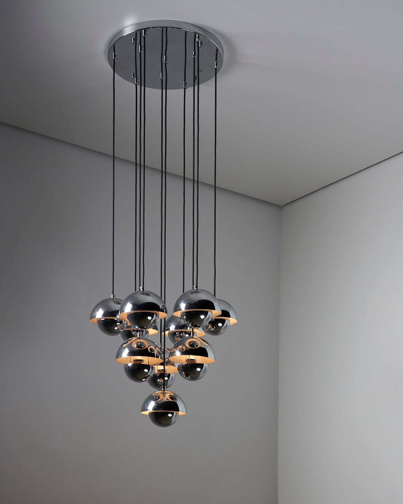 Modern chandelier with multiple pendant lights in a sleek, contemporary design illuminating a minimalist interior space.