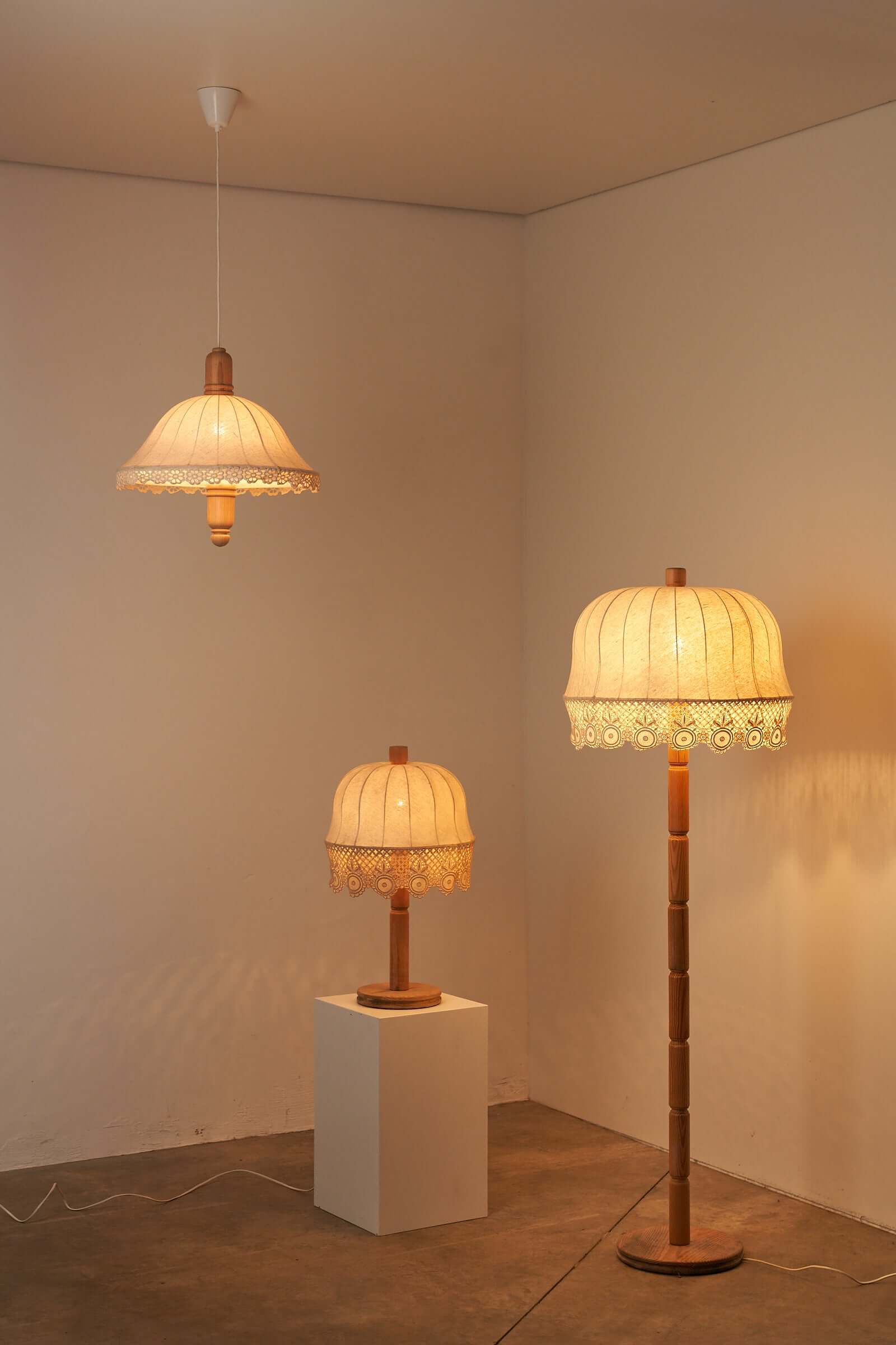 Three vintage lighting fixtures from Aneta Sweden, showcasing elegant designs and craftsmanship in a display setting.