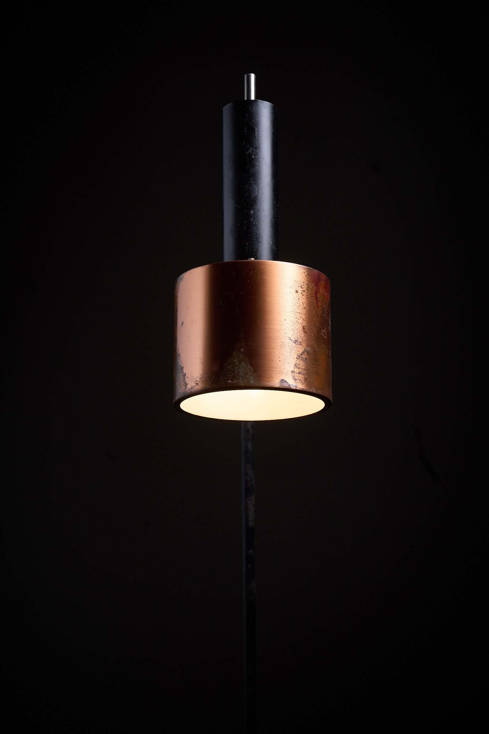 Floor lamp in black steel and copper shade, 1970s, showcasing warm patina and sculptural design.