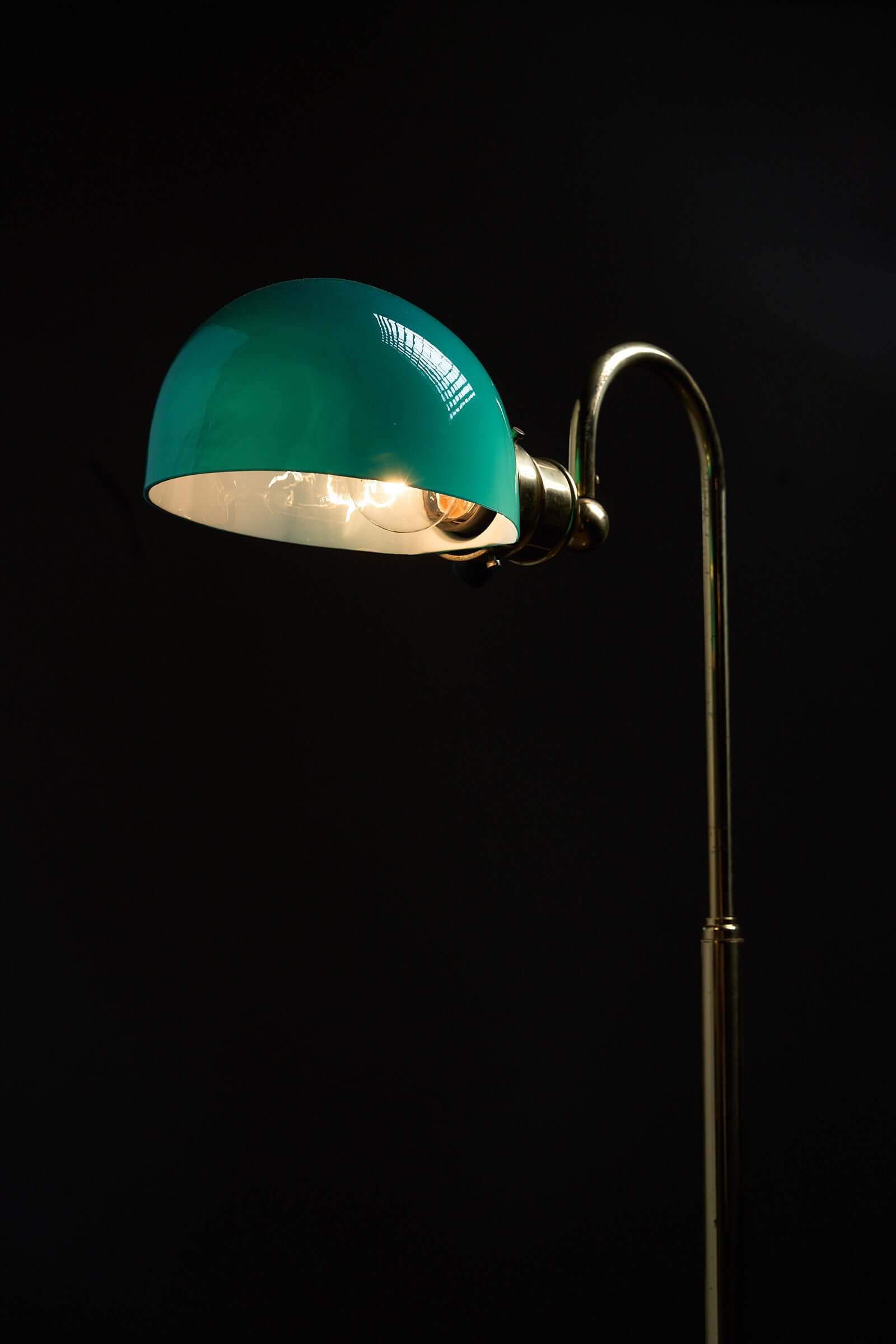 Floor lamp in brass with green glass shade, 1970s designed with a curved arm and striking green shade.