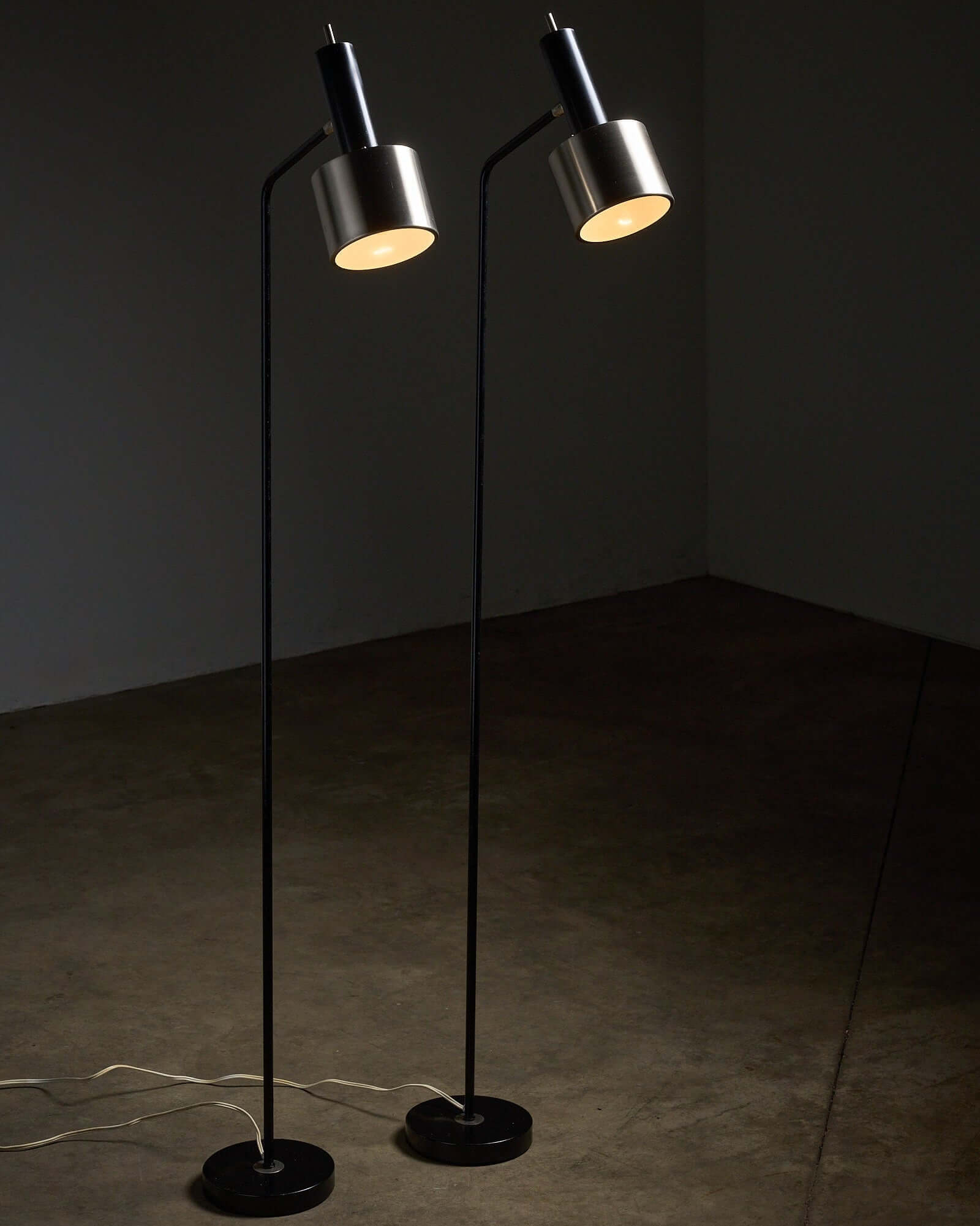 Pair of floor lamps in black metal with brushed aluminum shades, 1970s in modern interior setting.