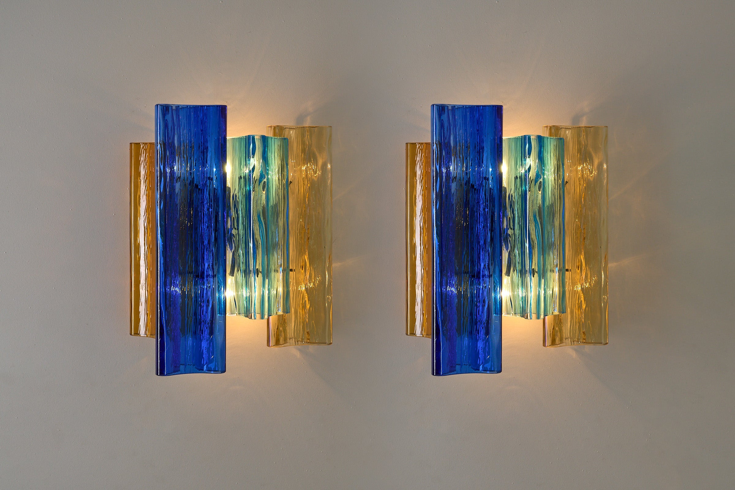 Unique pair of multicolor Murano glass wall lamps by Salviati & Co., Italy, circa 1970s featuring blue, amber, and aqua tones.