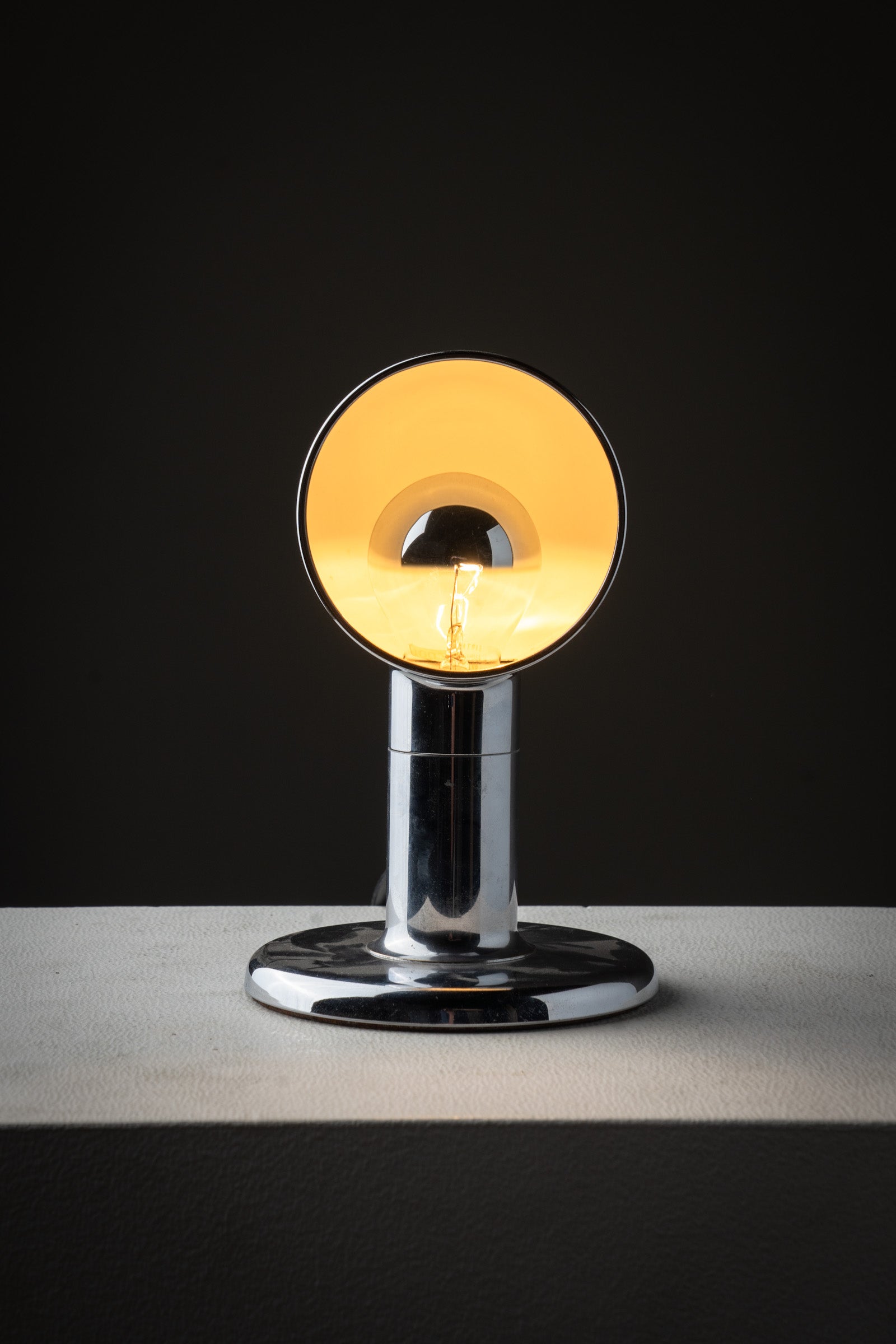 Small Space Age Chrome Table Lamp, 1970s with a semi-spherical shade and cylindrical base, displaying warm light.