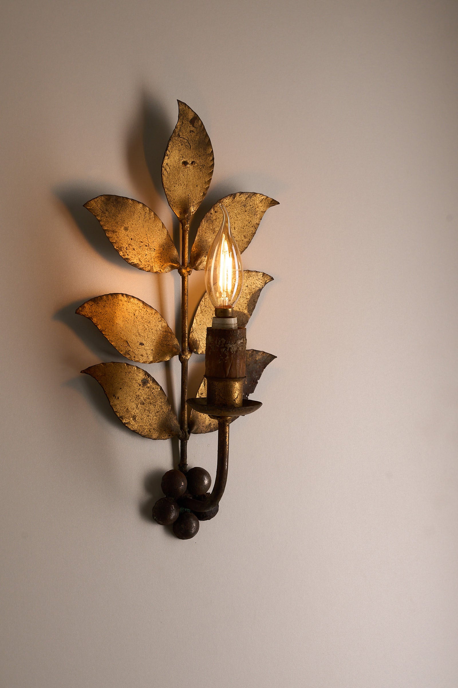 Brass Leaf Wall Sconce, 1920s showcasing hand-shaped brass leaves and vintage-style light bulb.