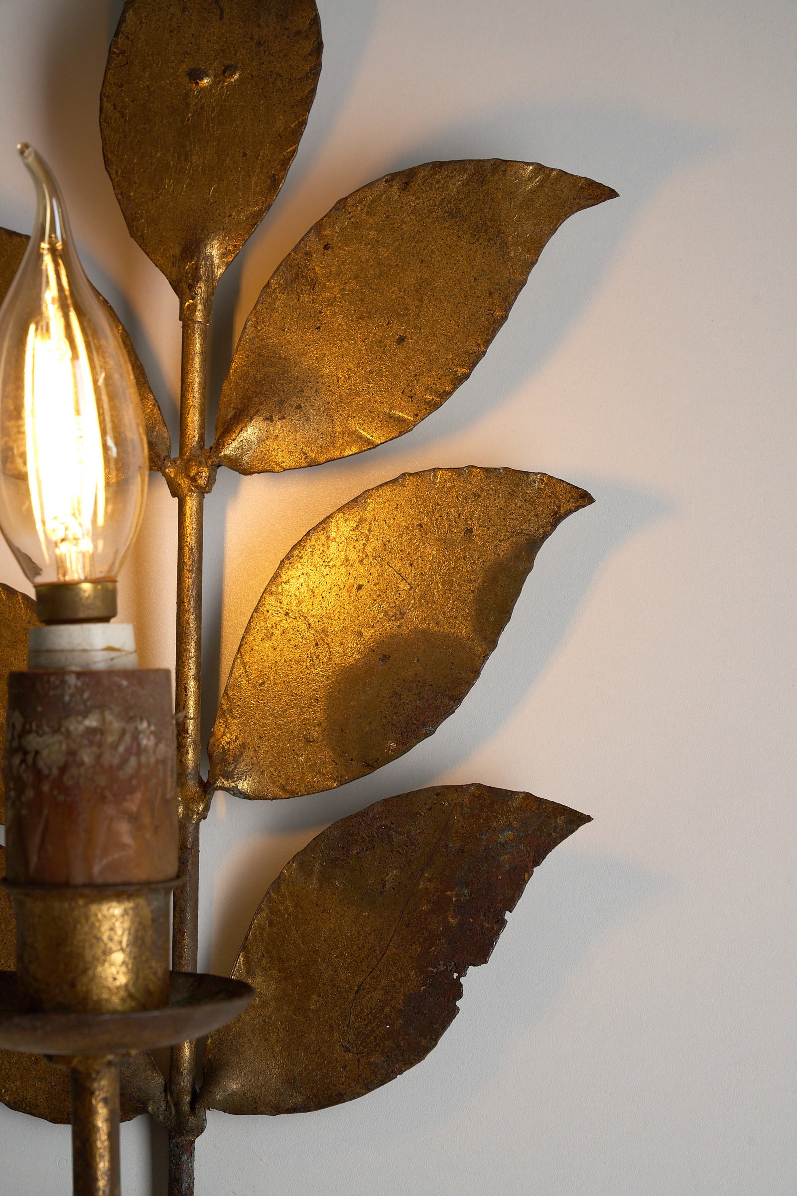 Brass Leaf Wall Sconce, 1920s featuring detailed leaf motifs and warm light.