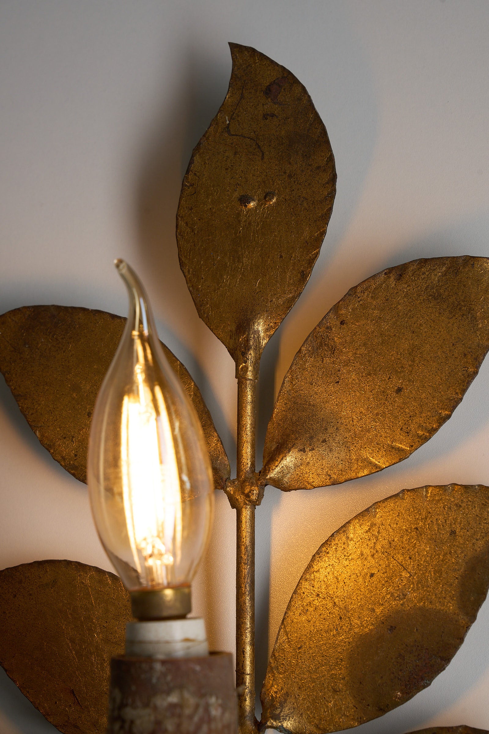 Brass Leaf Wall Sconce, 1920s showcasing hand-shaped brass leaves and warm bulb lighting.