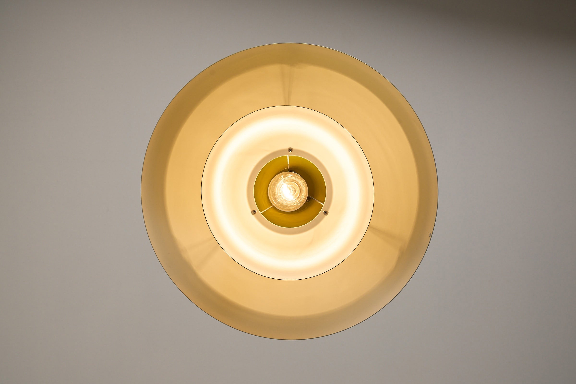 Fog & Mørup Yellow Metal Pendant Lamp, Denmark, 1960s - overhead view of the lamp shade and light bulb.