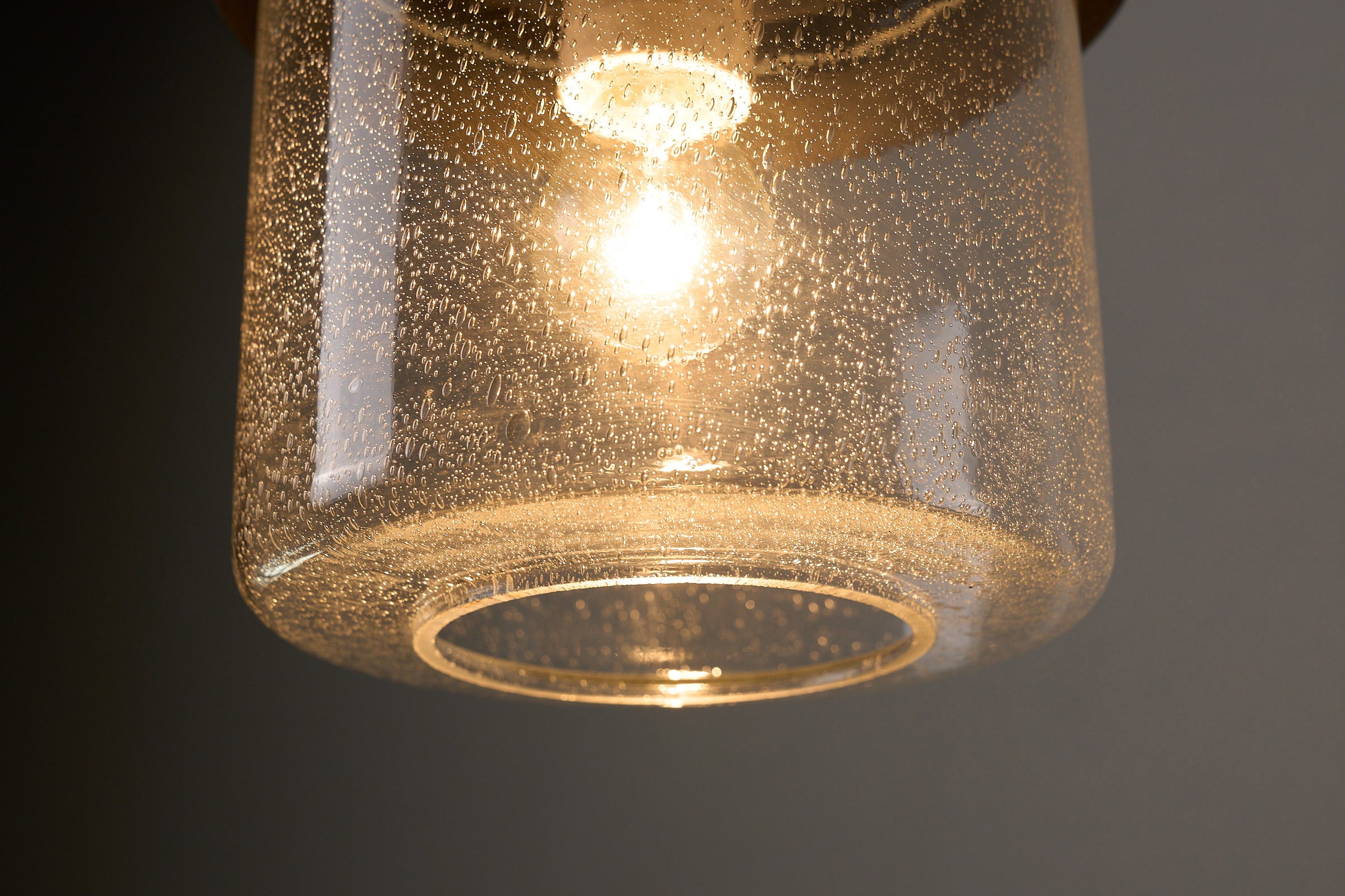 Detail of the BOOM Ceiling Lamp, Black Metal & Bubble Glass Pendant showcasing the bubble glass diffuser and warm light.