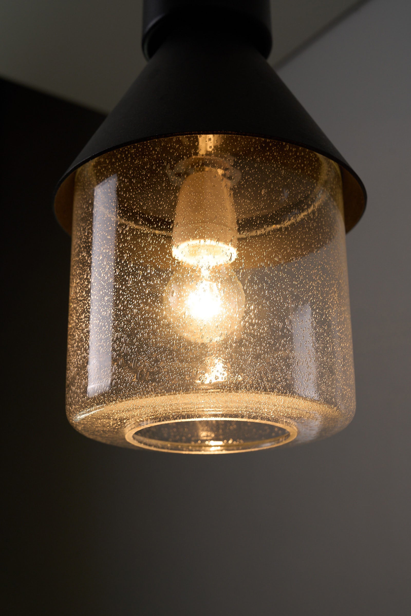 BOOM Ceiling Lamp, Black Metal & Bubble Glass Pendant featuring bubble glass and warm light glow.