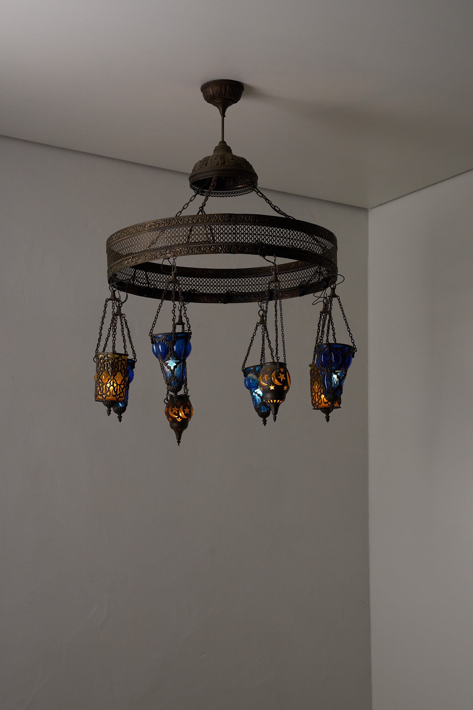 Moroccan Chandelier with Six Colored Glass Pendants showcasing intricate brasswork and vibrant amber and cobalt blue glass.