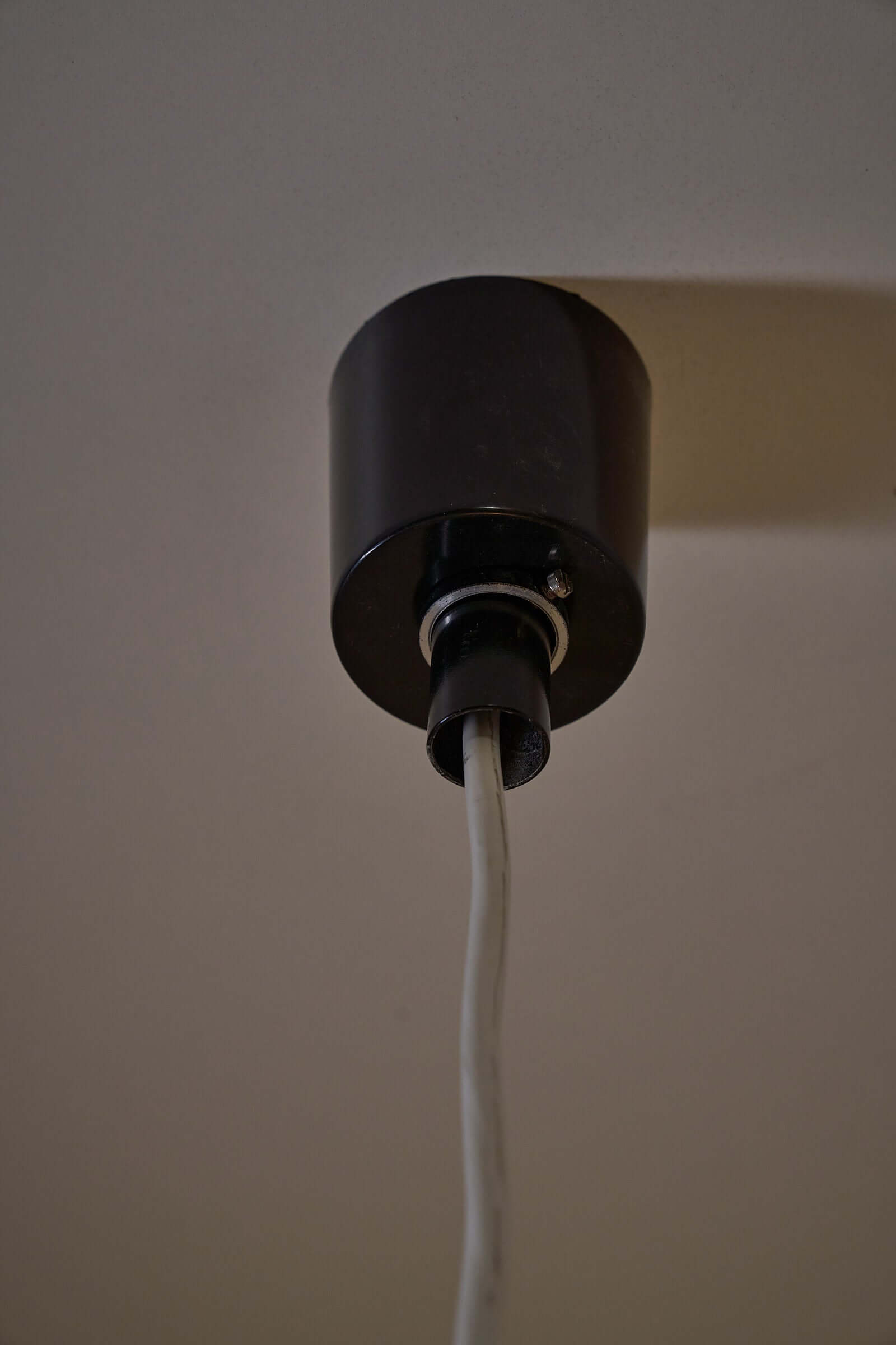 Ceiling mount for Carlo Nason Two-Tone Glass Chandelier, White featuring a black base and hanging cable.