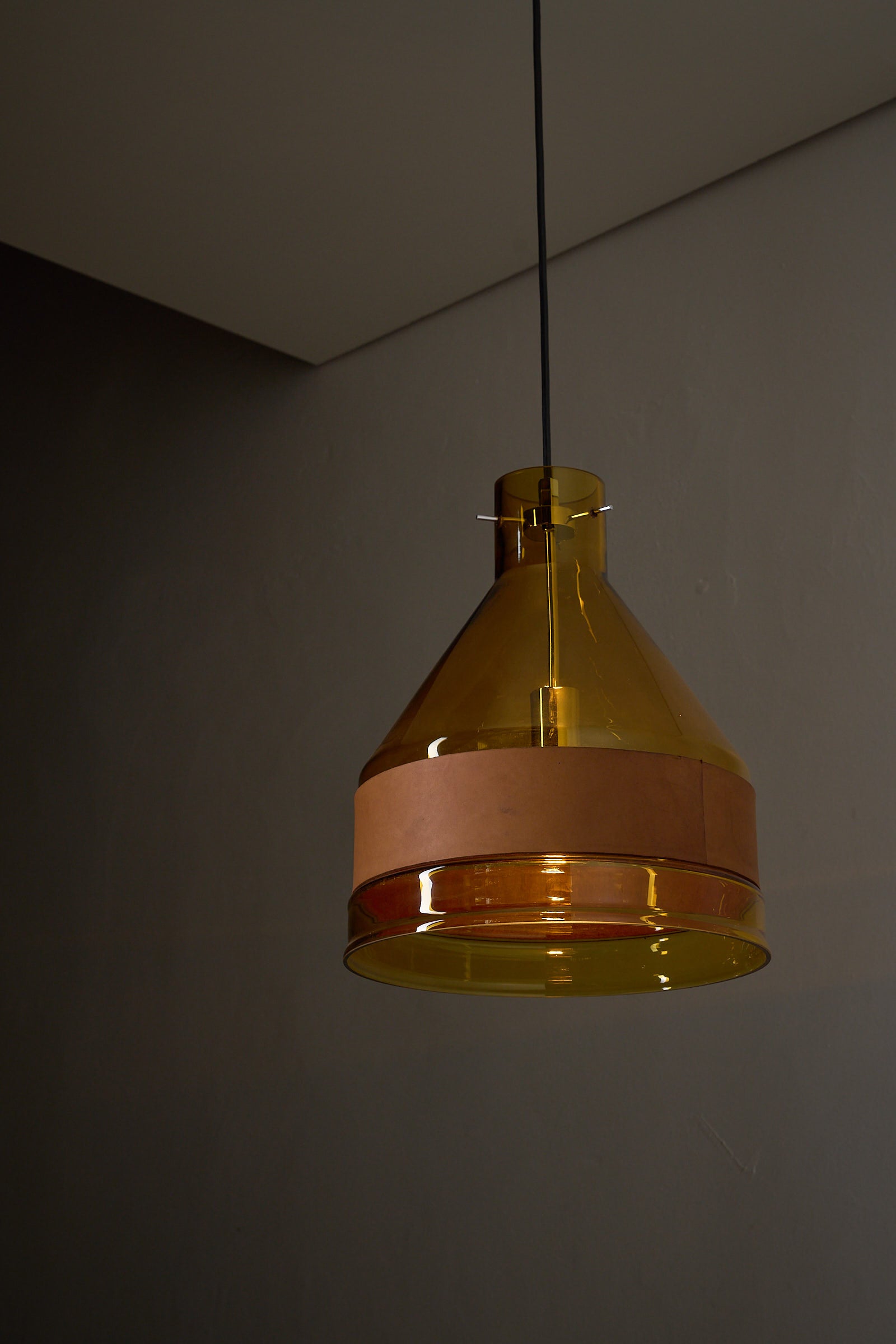 Amber Glass and Leather Pendant Lamp by J.T. Kalmar hanging in a modern interior, showcasing its distinctive design.