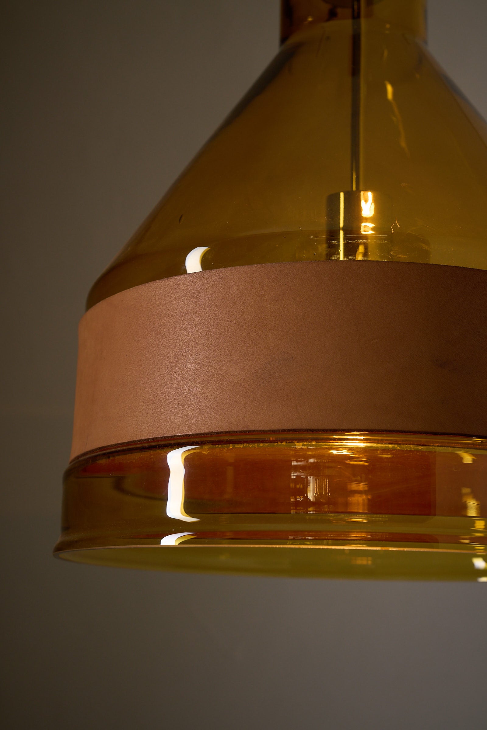 Amber Glass and Leather Pendant Lamp by J.T. Kalmar featuring a hand-blown amber shade and leather band.