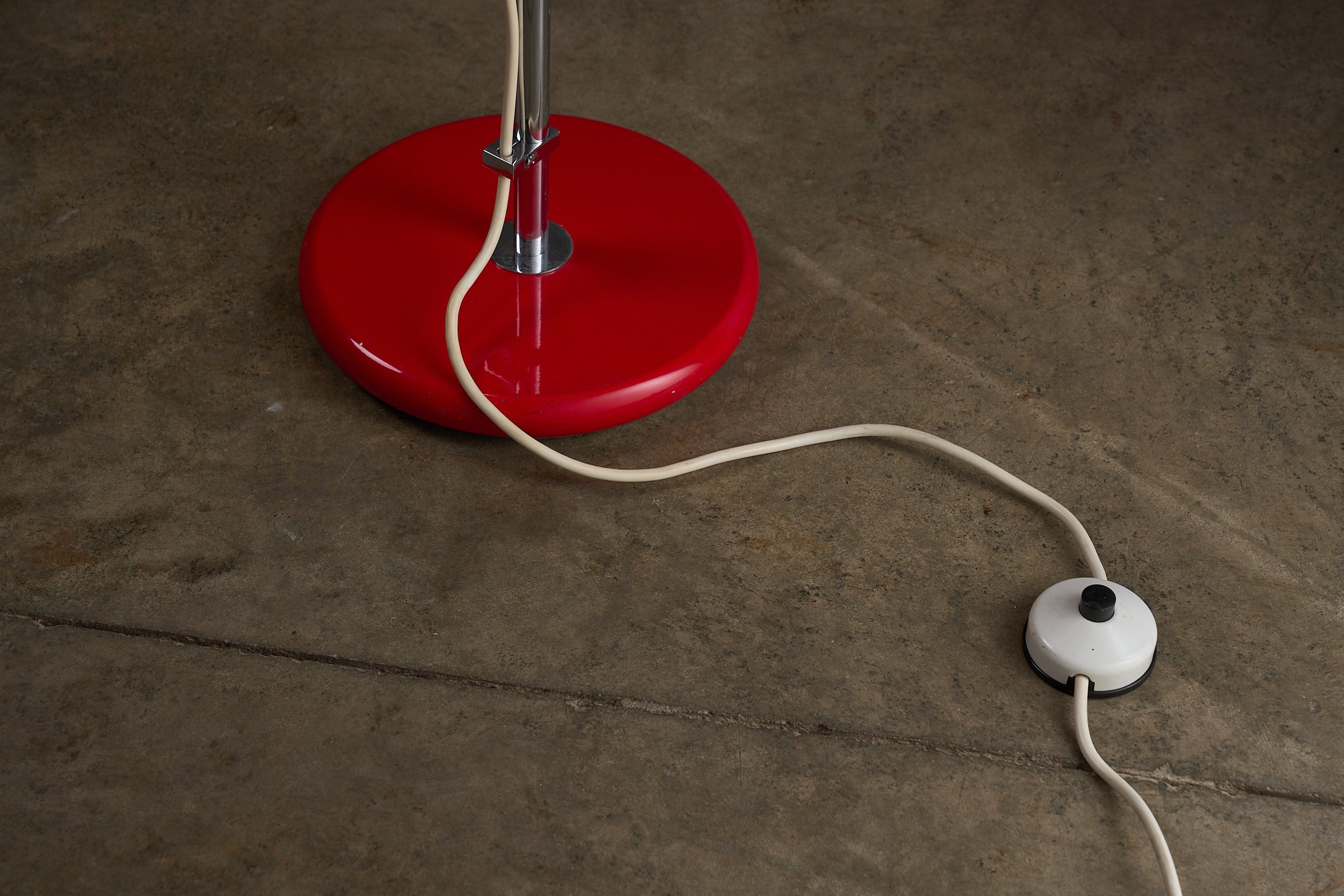 Red Sphere Floor Lamp by Cosack, Germany 1960s with a red base and power cord on a concrete floor.