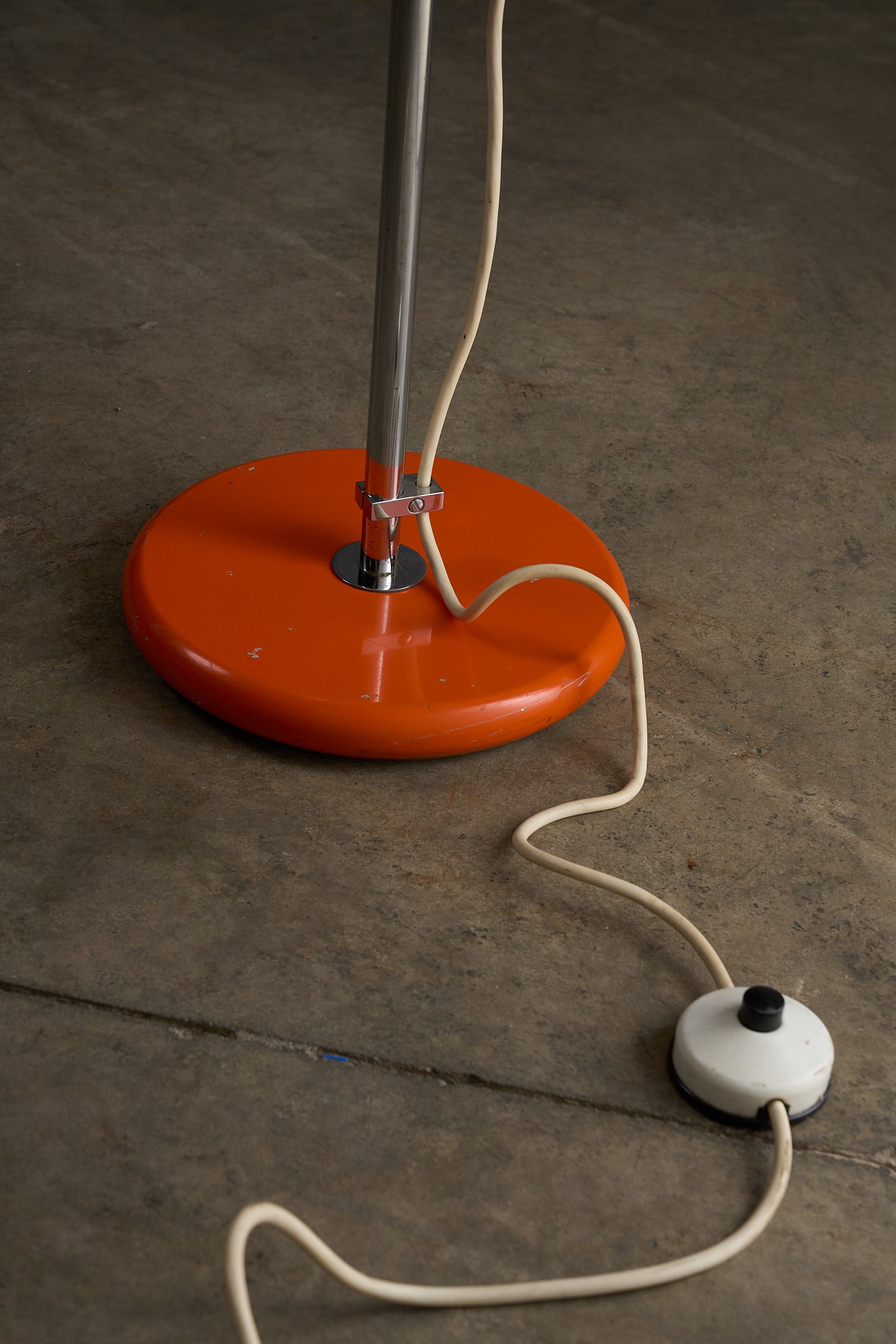 Orange Sphere Floor Lamp with Diffuser base and cord detail on a concrete floor.