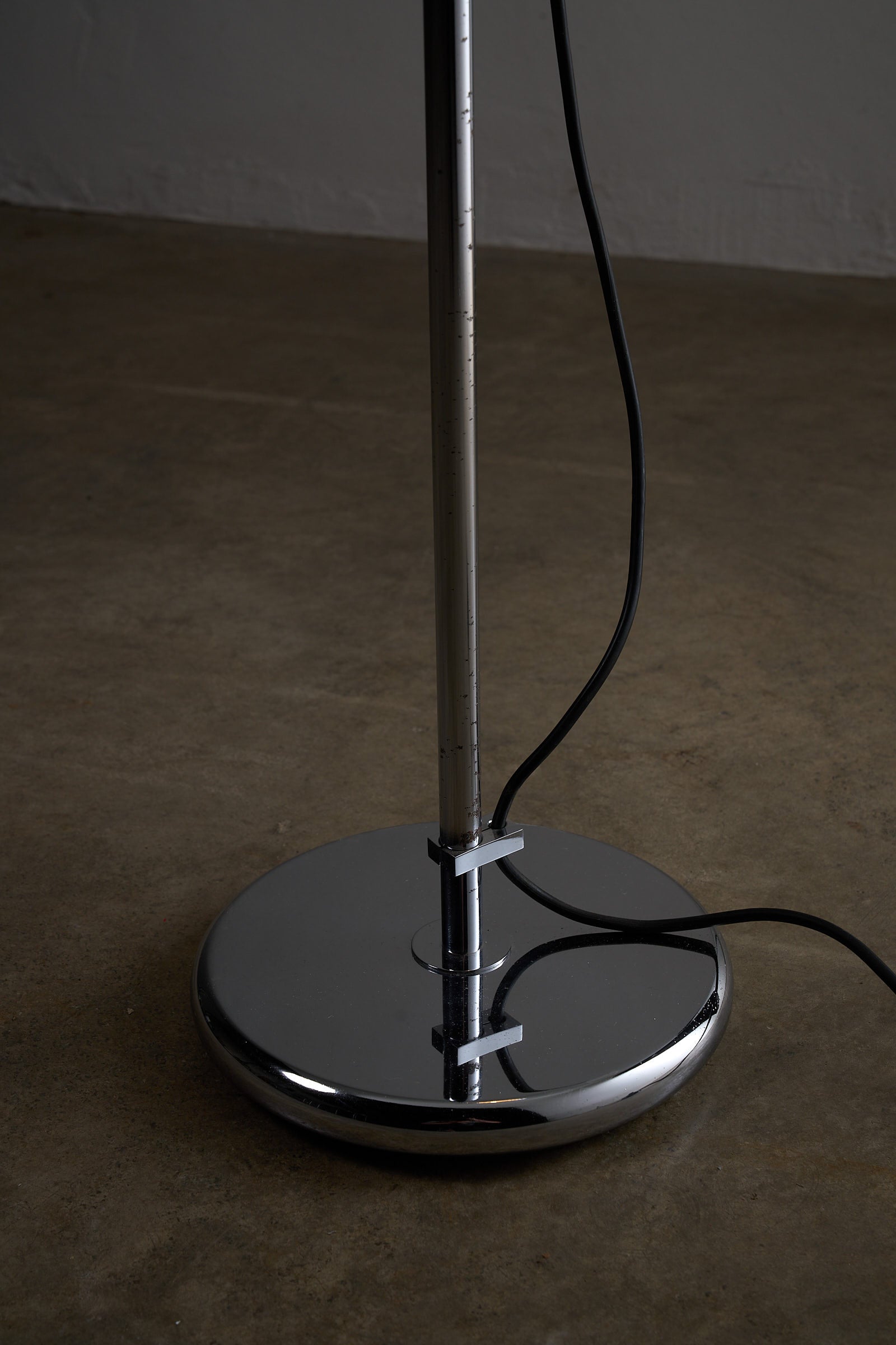 Close-up view of the base and stem of a Chrome Sphere Floor Lamp showcasing its sleek chrome design.