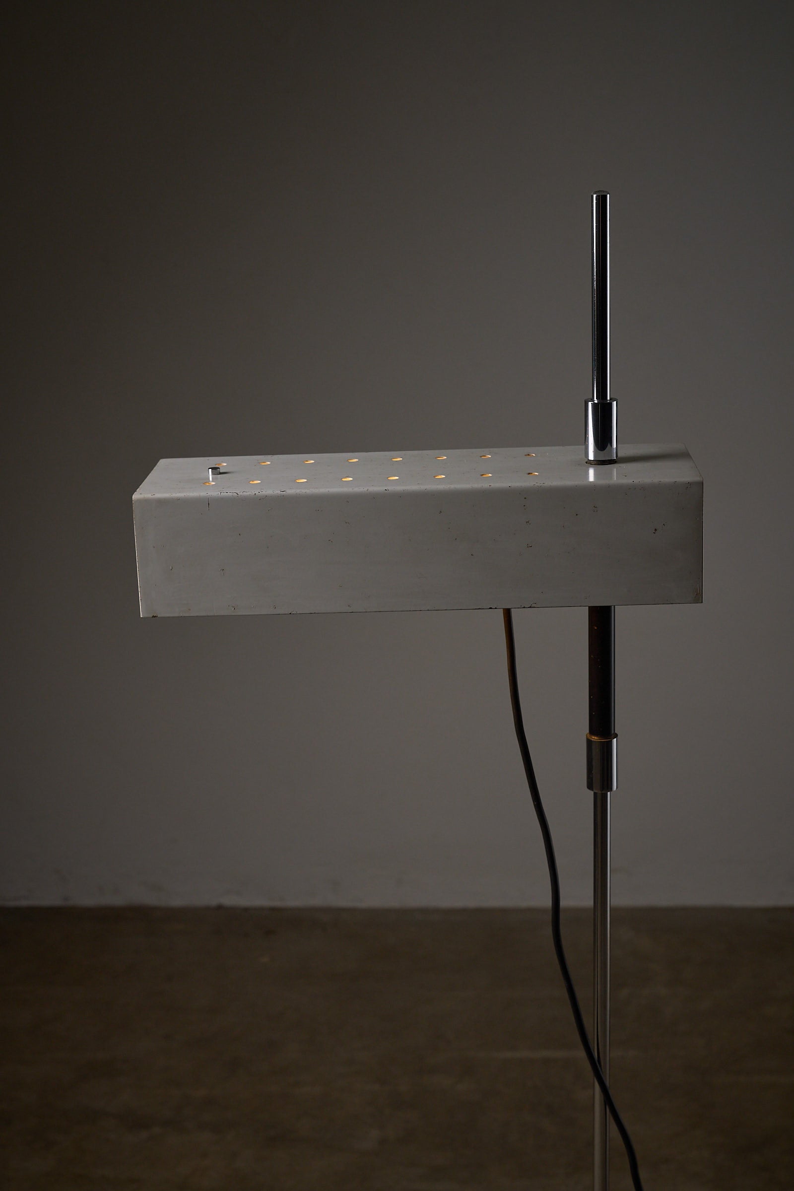 Adjustable Perforated Shade Floor Lamp with a sleek design and chromed base, perfect for modern interiors.