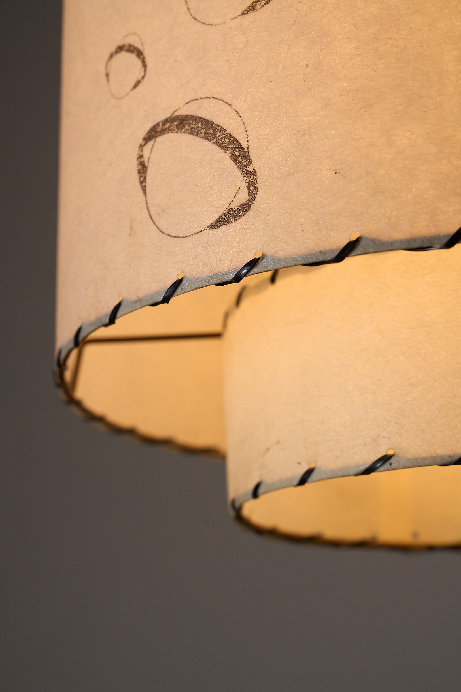 Parchment Pendant Lamp by Archaic Smile Inc detail showing double-tiered parchment shade with planet pattern.
