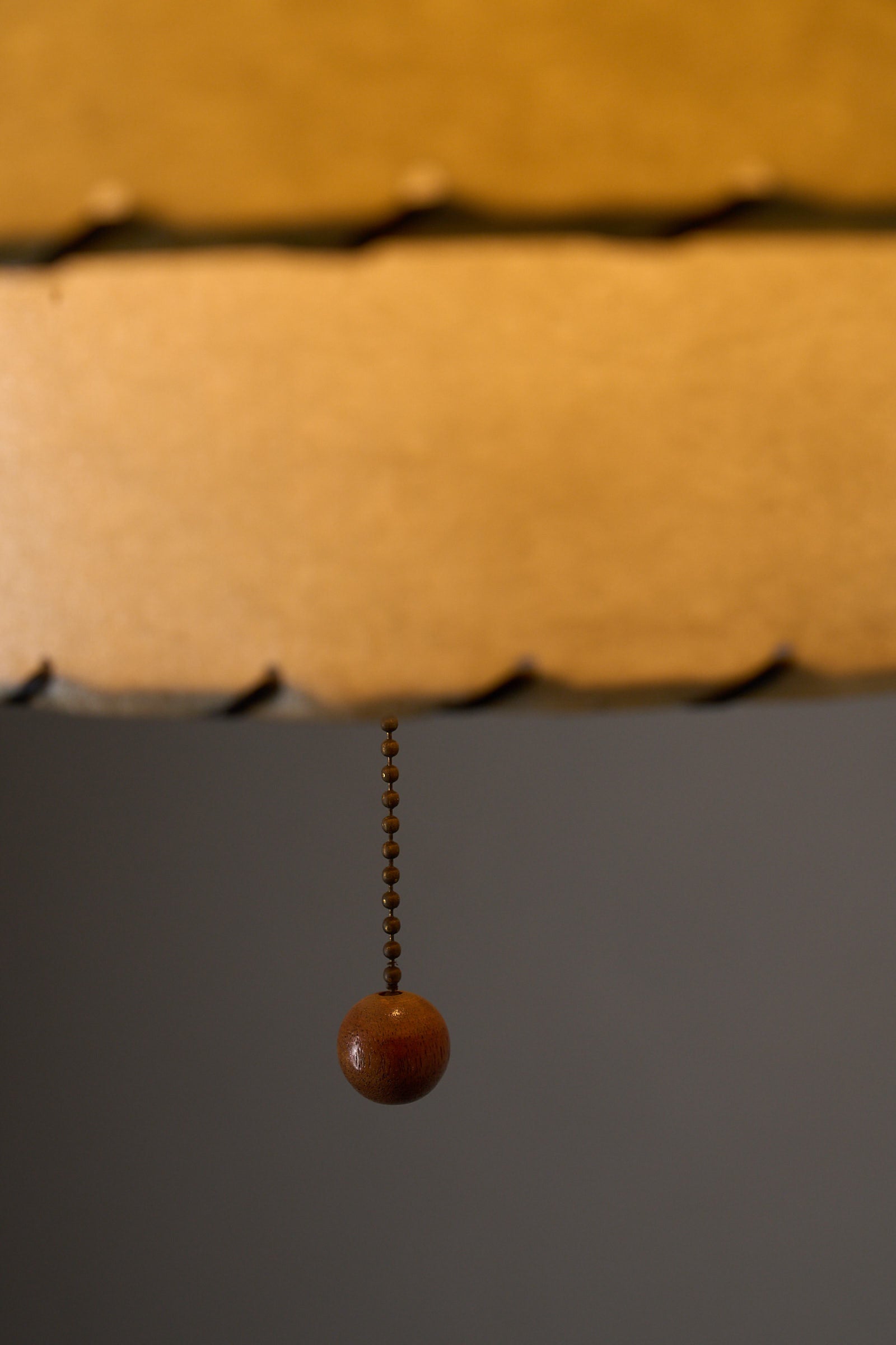 Close-up of the pull chain of the Atomic Pendant Lamp by Archaic Smile Inc, showcasing its unique design and materials.