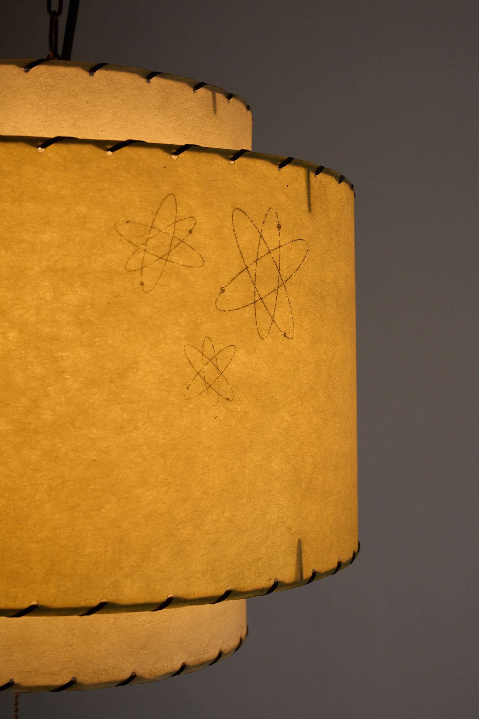 Atomic Pendant Lamp by Archaic Smile Inc with double-tiered parchment shade featuring atomic pattern.