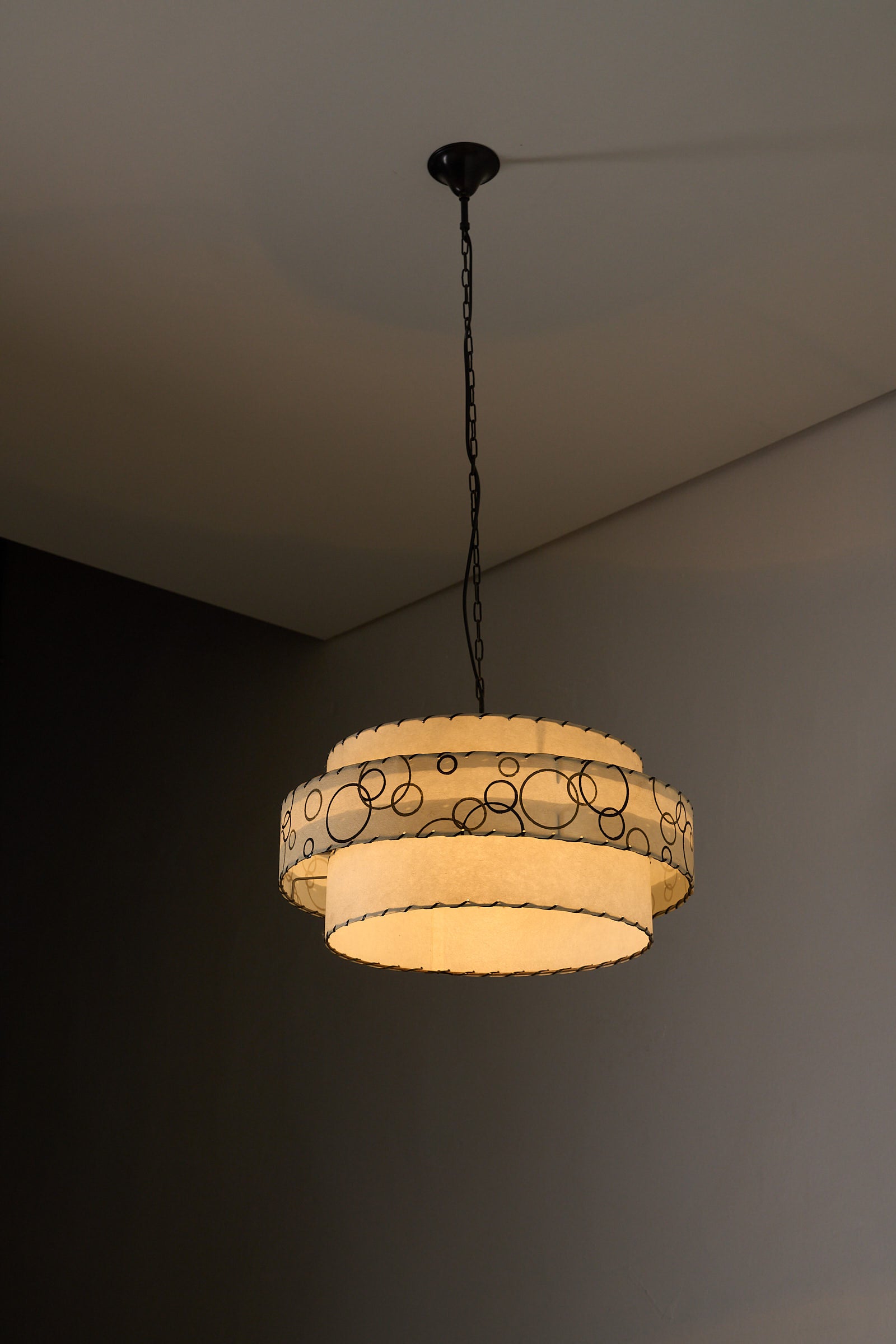 Bubble Motif Pendant Lamp by Archaic Smile Inc. featuring double-tiered parchment shade and circular pattern.