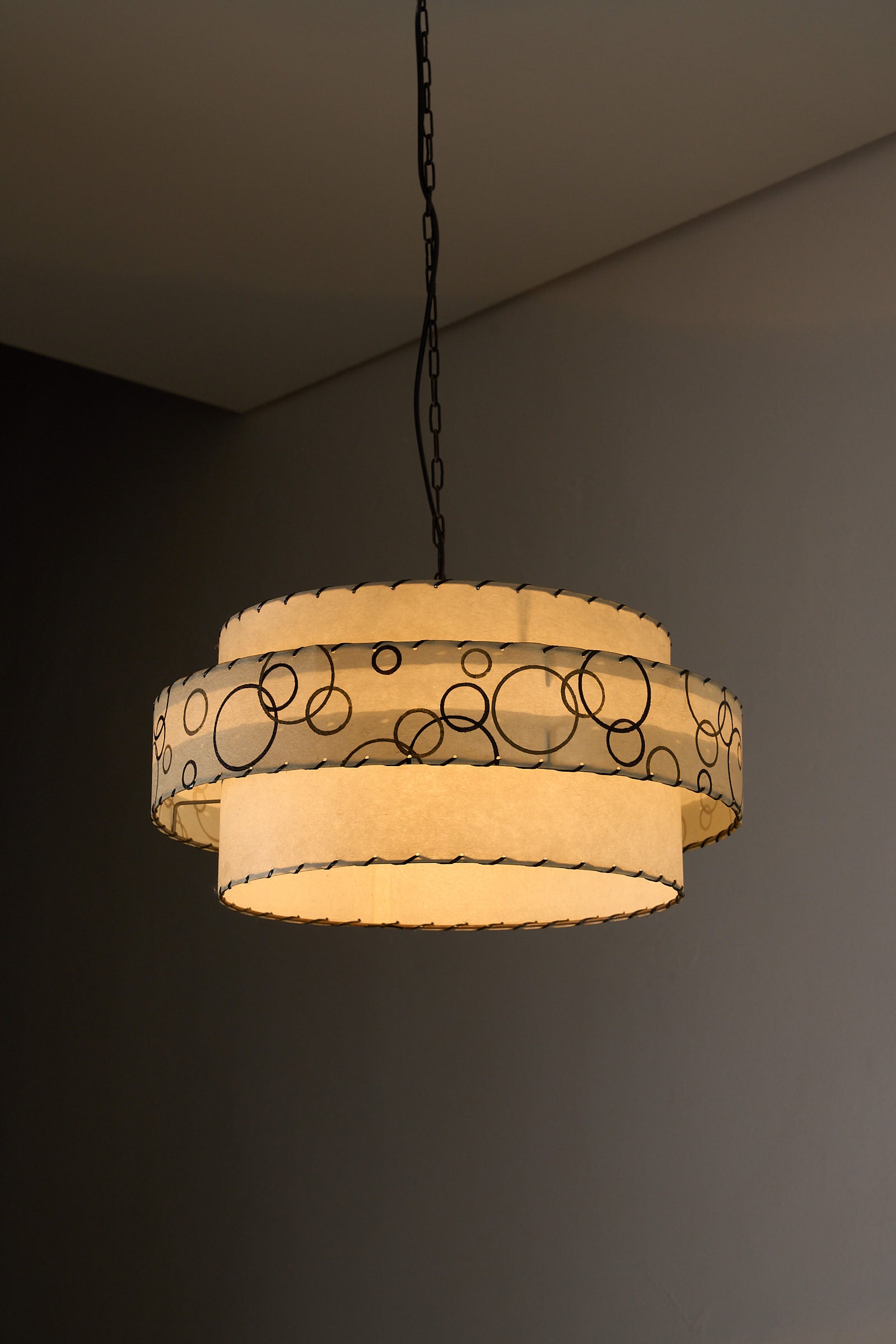 Bubble Motif Pendant Lamp by Archaic Smile Inc. featuring double-tiered parchment shade with circles pattern.