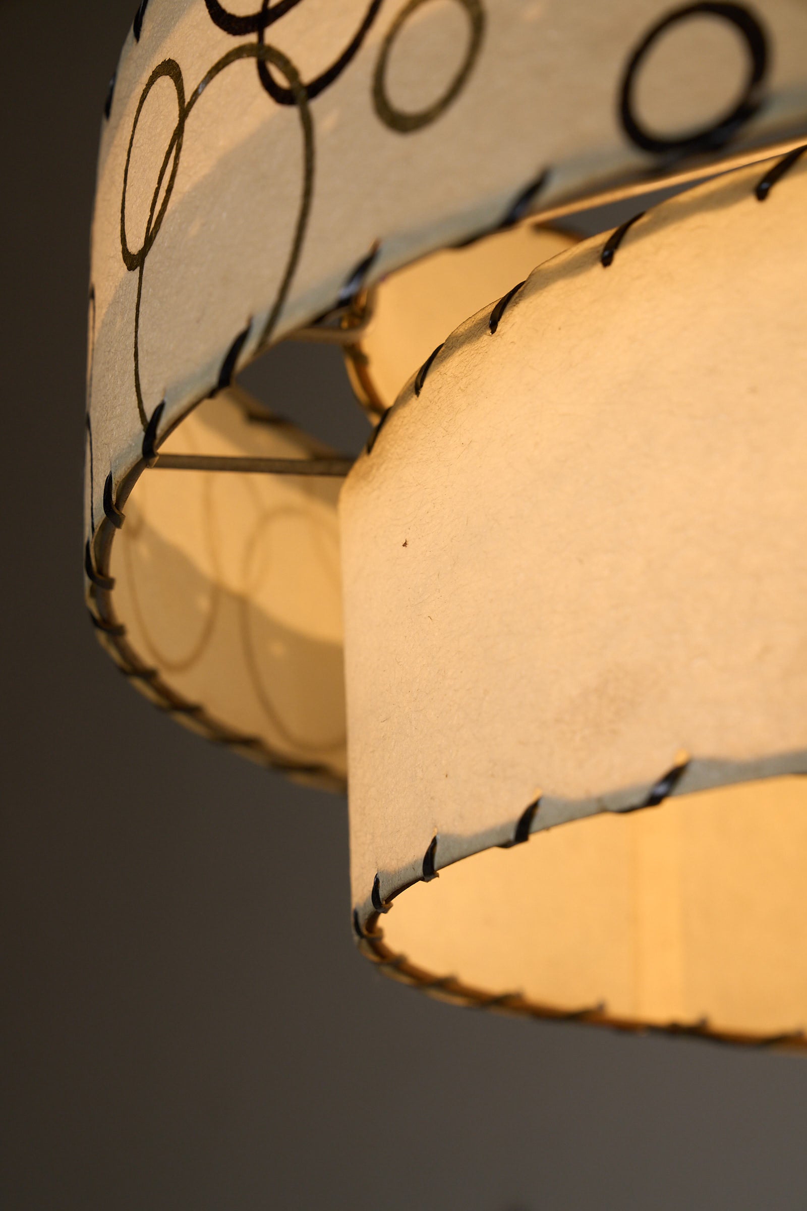 Bubble Motif Pendant Lamp by Archaic Smile Inc. showcasing double-tiered parchment shades with circles pattern.