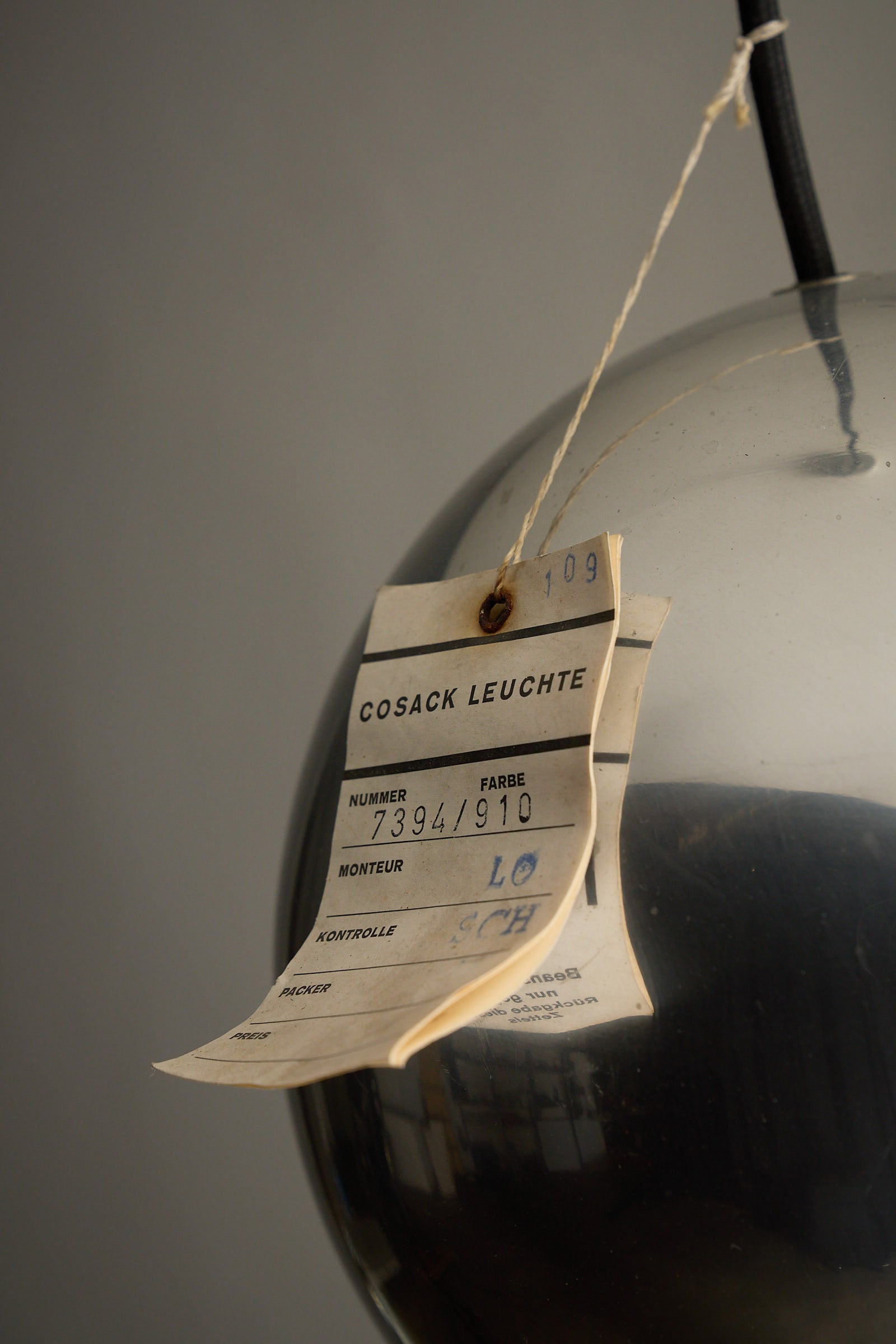Tag details from the Chrome Sphere Pendant by Cosack Leuchte, showcasing its design and vintage authenticity.