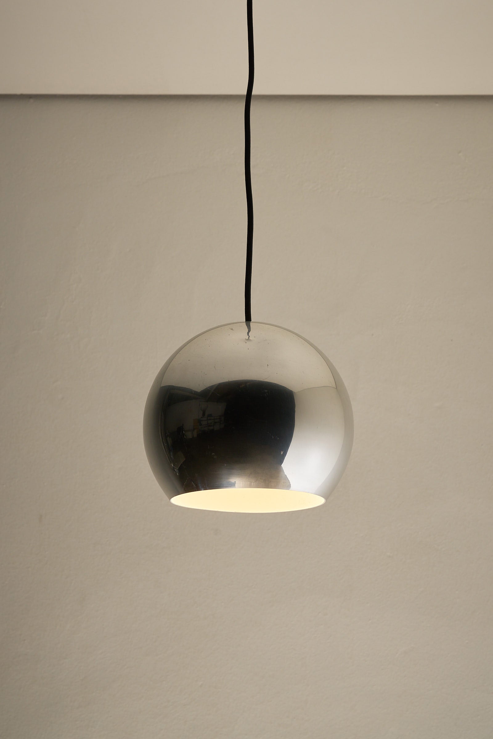 Chrome Sphere Pendant hanging lamp with a polished chrome finish, embodying mid-century design elegance.