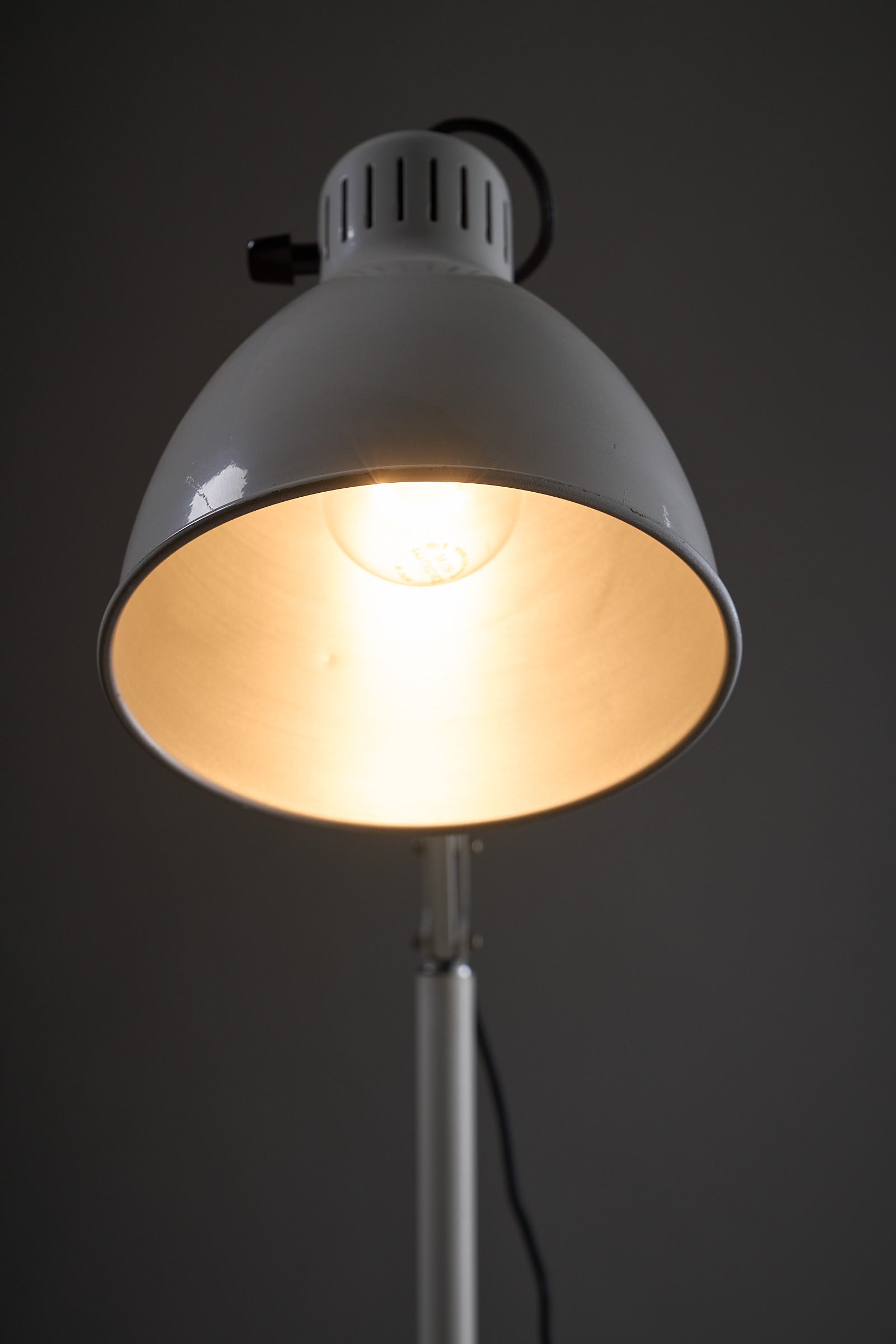 Metalarte “Arma” Adjustable Floor Lamp in White Enamel, 1970s featuring a white shade and illuminated light bulb.