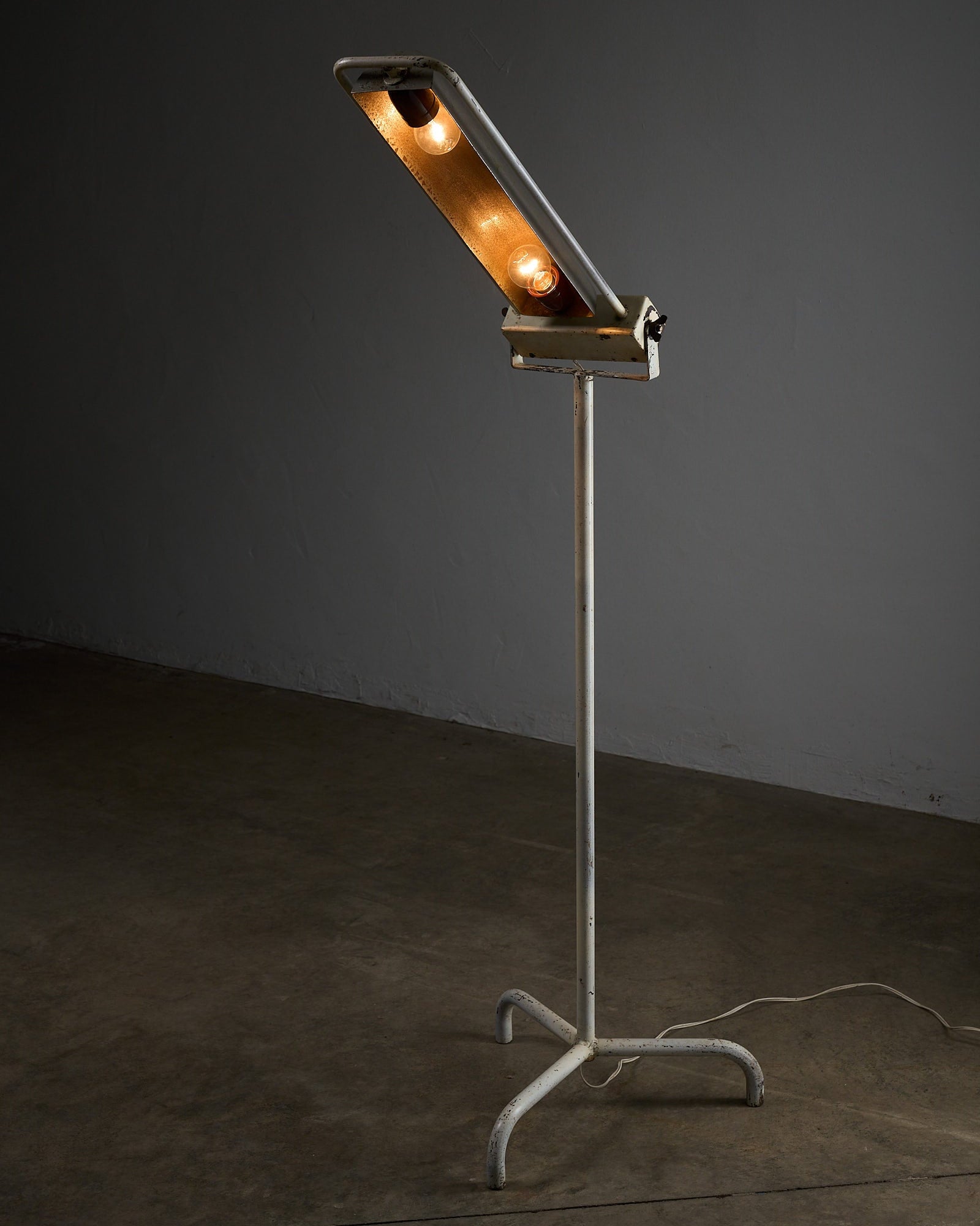 Industrial Medical Floor Lamp, Adjustable Enamel and Metal Construction with adjustable reflector and three-legged base.