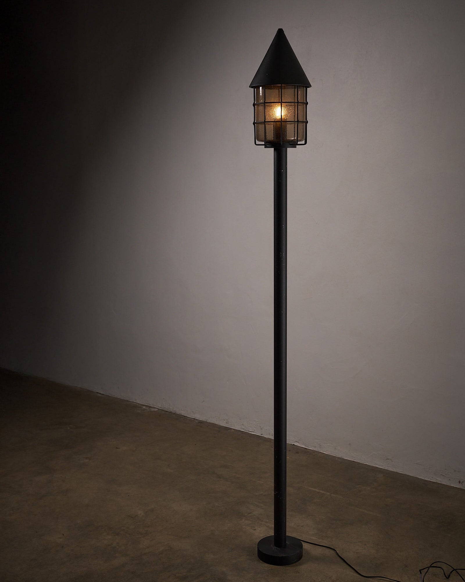 Tall Outdoor Lantern by Boom BEGA featuring a tapered shade and cylindrical post for enduring outdoor lighting.