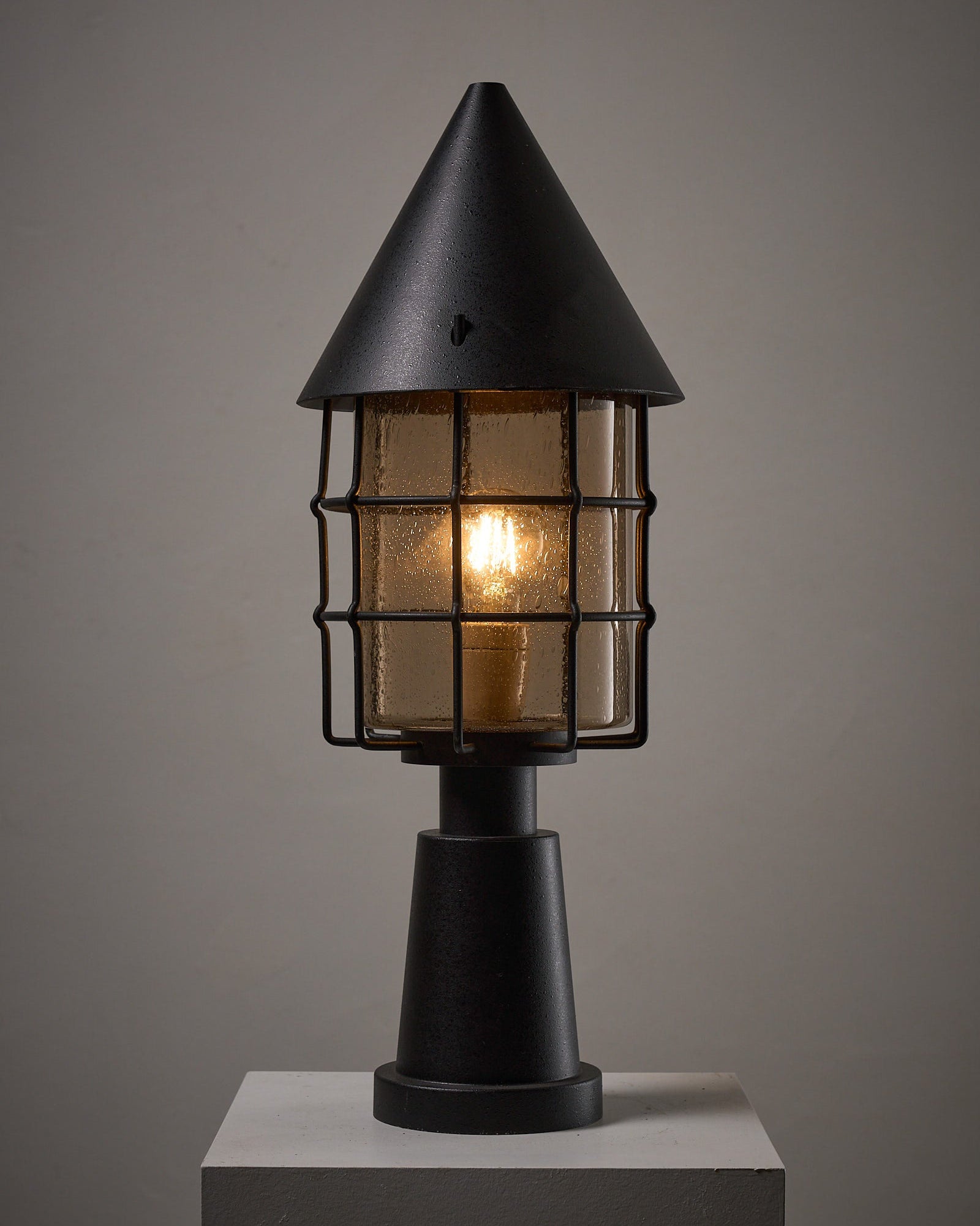 Outdoor Lantern by Boom BEGA showcasing a compact architectural design with conical top and protective cage.