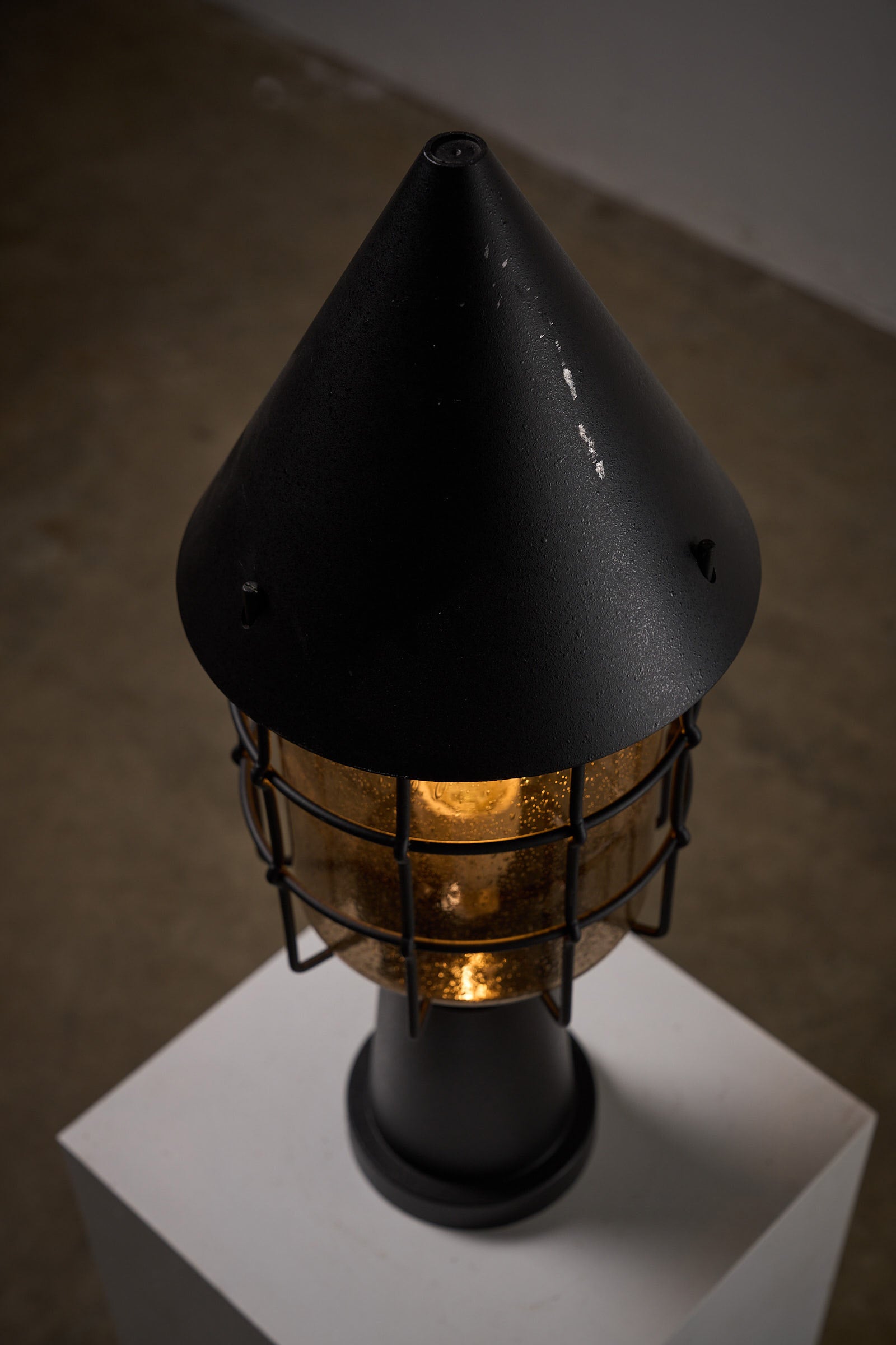 Outdoor Lantern by Boom BEGA featuring conical top and protective cage for durability and elegance.