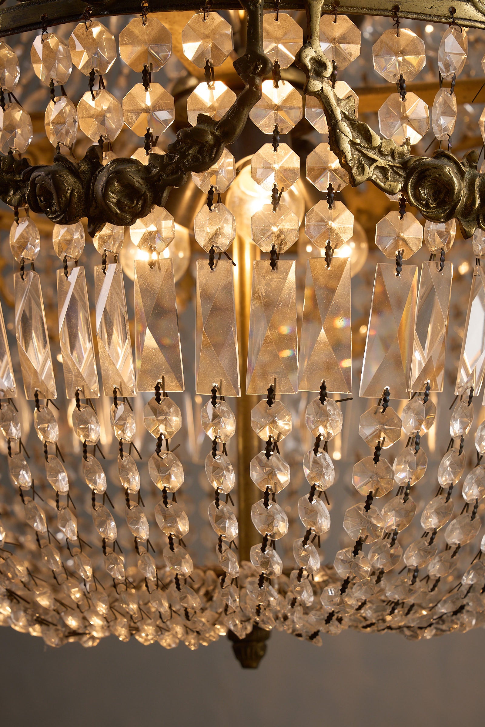 Close-up of a Medium Empire-Style Brass and Crystal Chandelier with Garland Detailing, 20th Century, showcasing crystal beads and lights.
