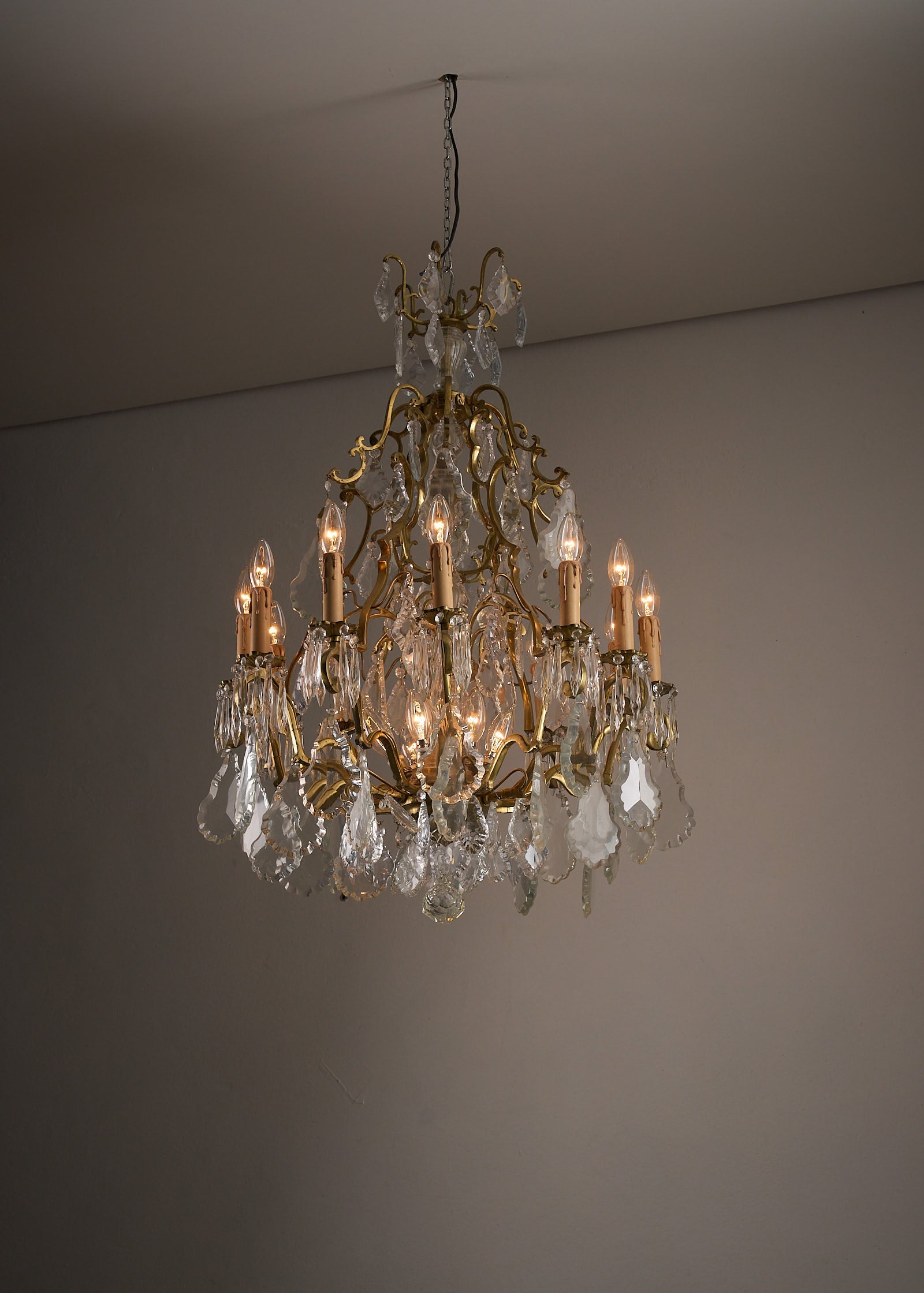 Empire-Style Chandelier in Brass and Crystal with ornate brass frame and crystal pendants, illuminating the room.
