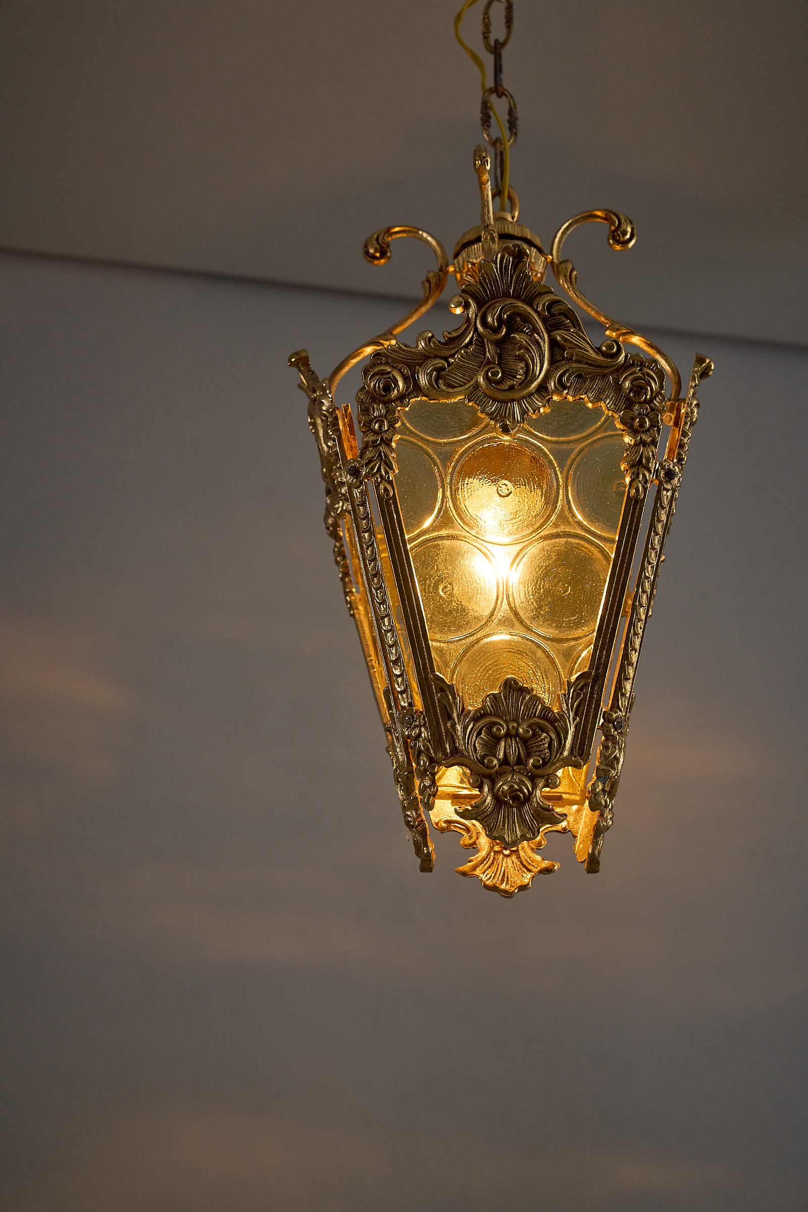 Rococo-Style Gilt Pendant Lamp with Structured Amber Glass hanging with ornate design and amber light.