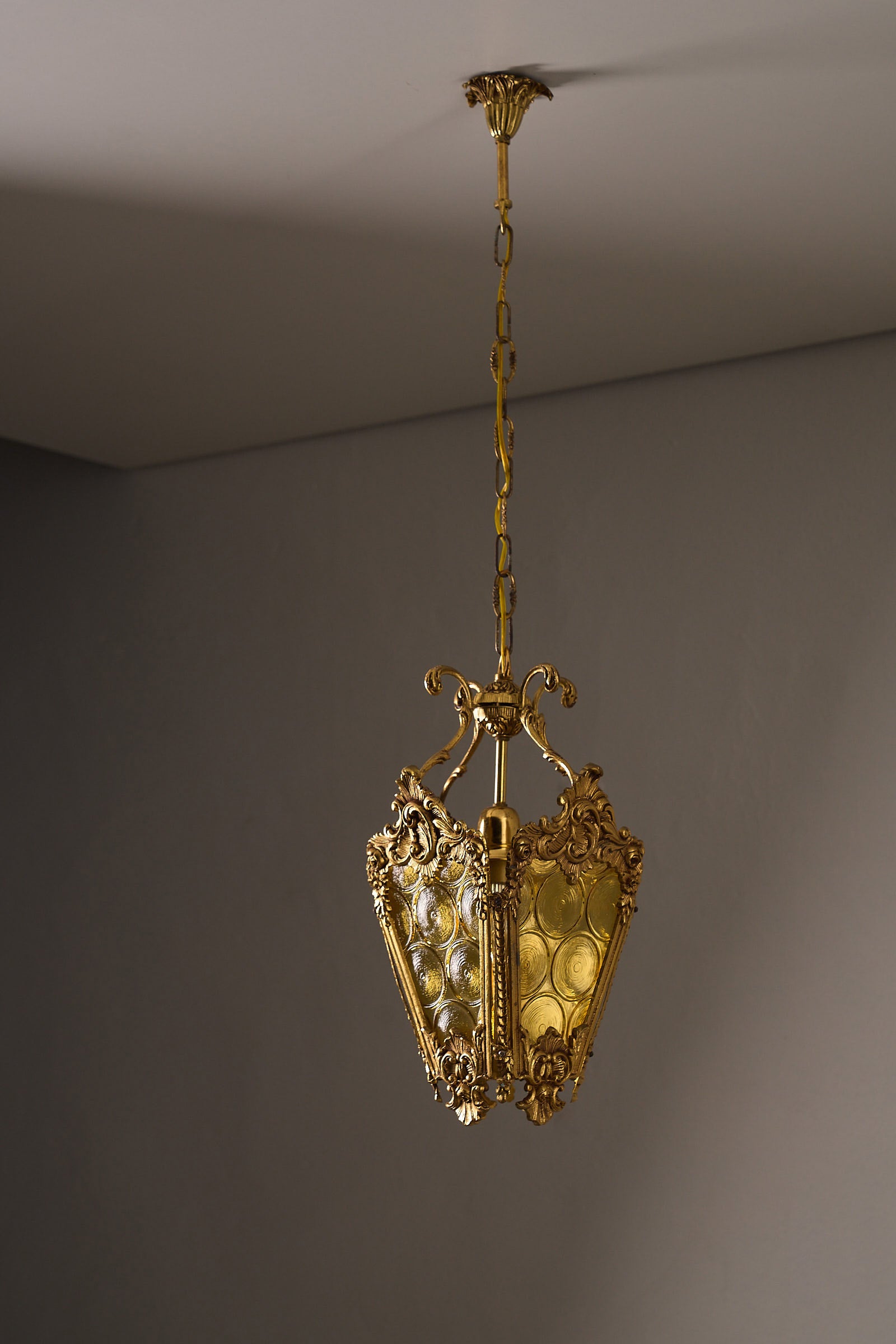 Rococo-Style Gilt Pendant Lamp with Structured Amber Glass hanging from a decorative chain, showcasing ornate design.