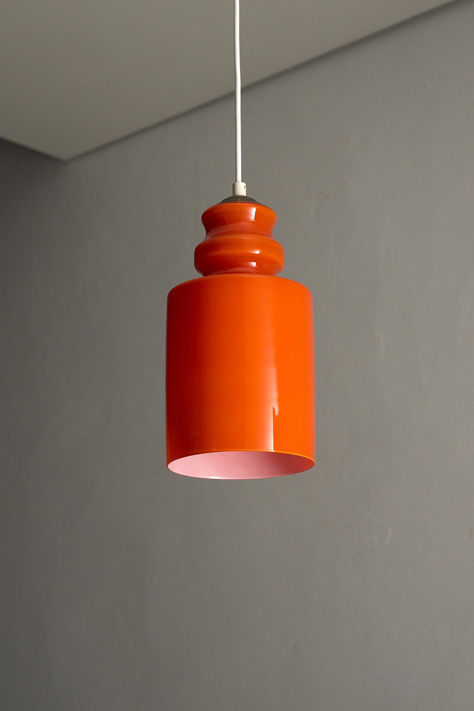Orange Glass Pendant Lamp featuring a glossy orange shade in a softly rounded form.