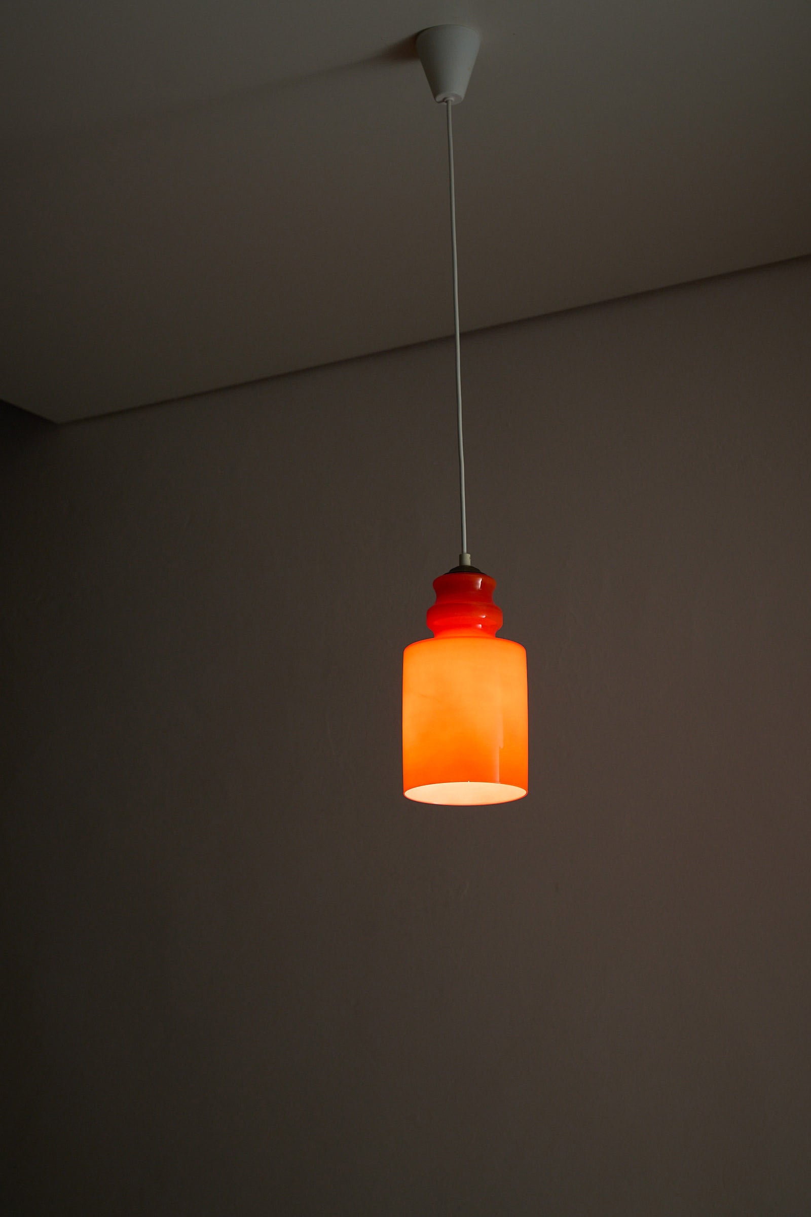 Orange Glass Pendant Lamp featuring a glossy orange glass shade, perfect for dining areas or cozy corners.
