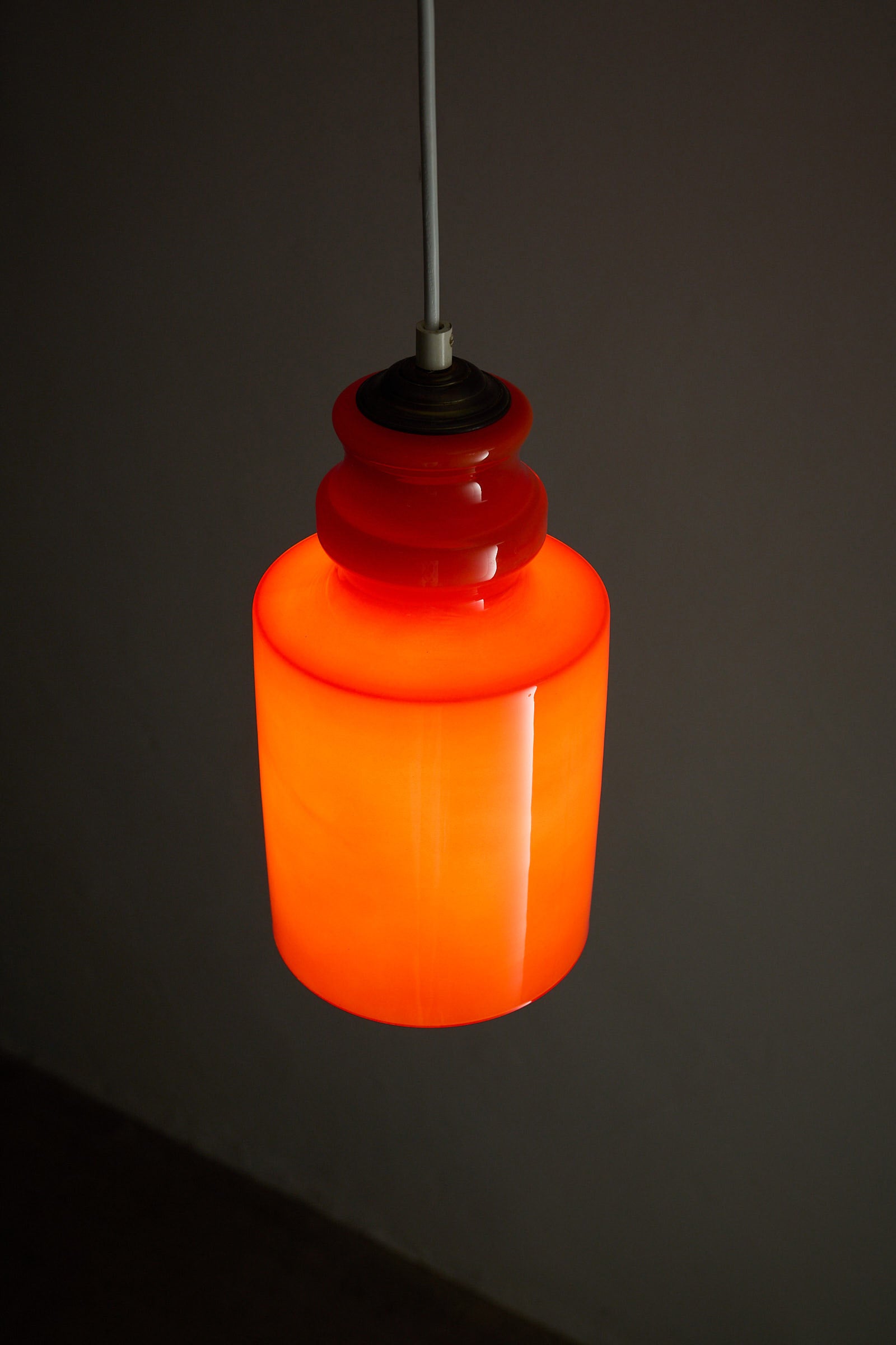 Orange Glass Pendant Lamp with glossy orange glass shade and softly rounded form.