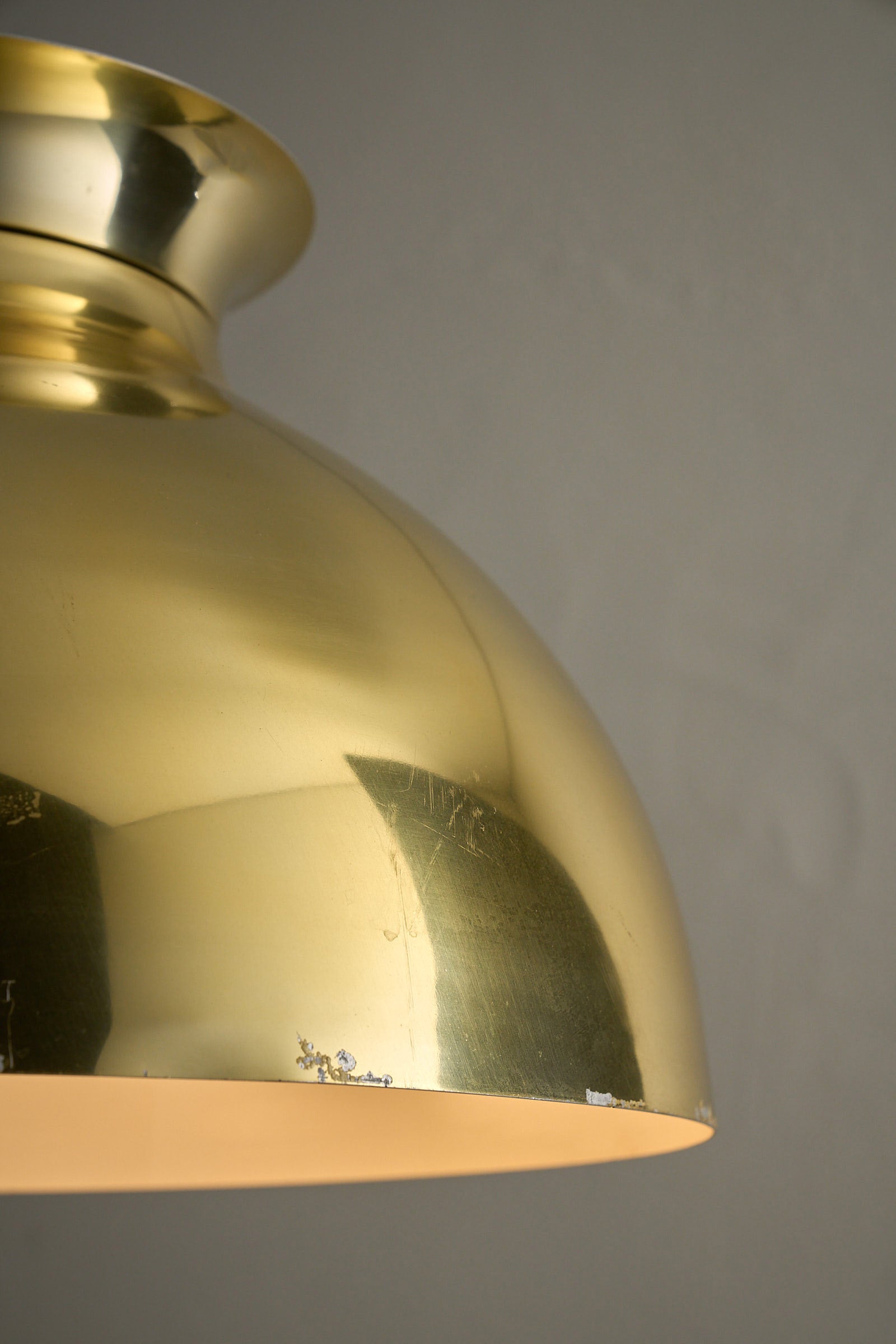 Close-up of a Large Brass Dome Pendant showing polished brass shade and subtle age wear.