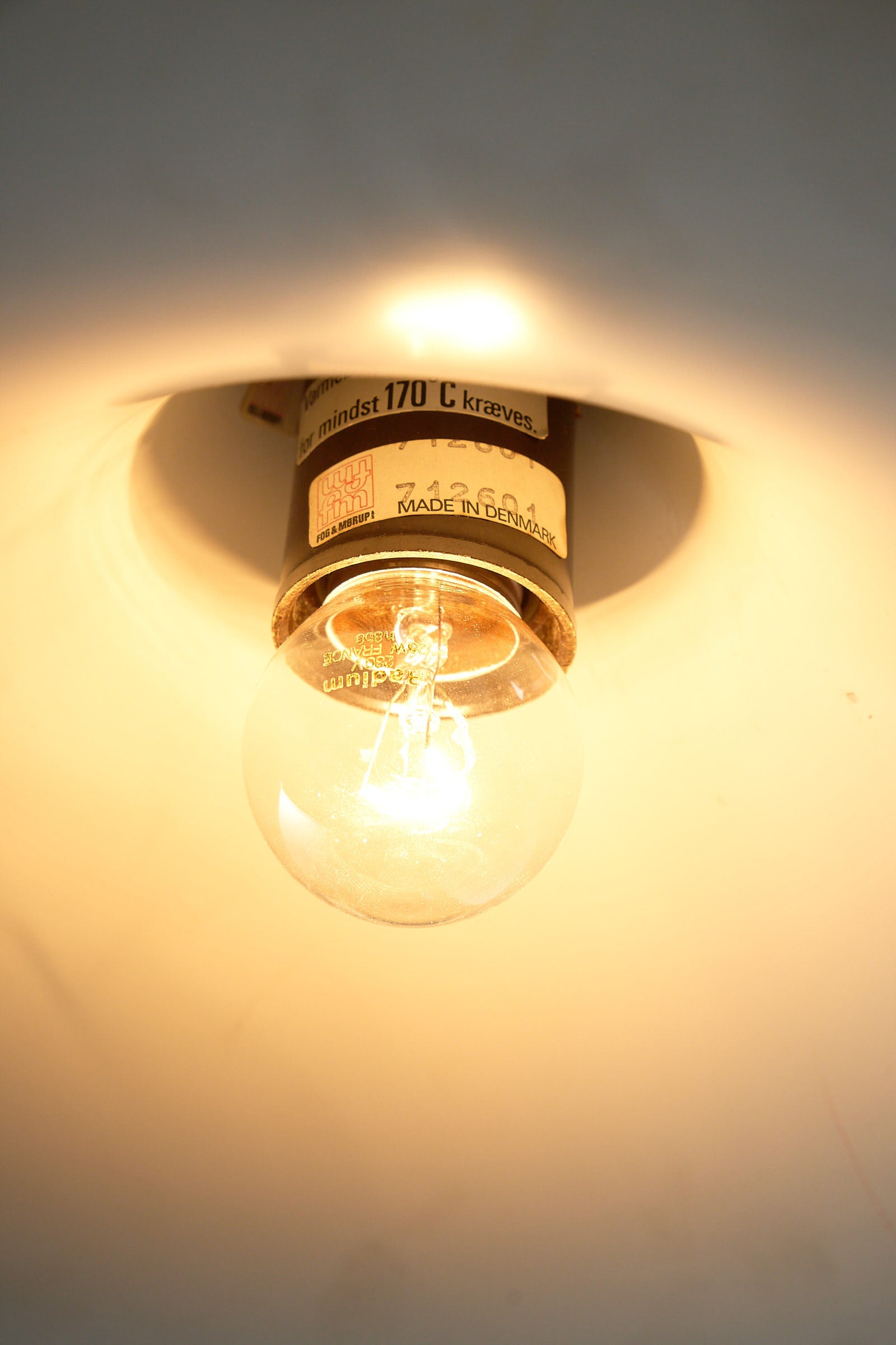 Fog&Mørup Red Semi Pendant Lamp showcasing a clear light bulb and vintage socket detail.