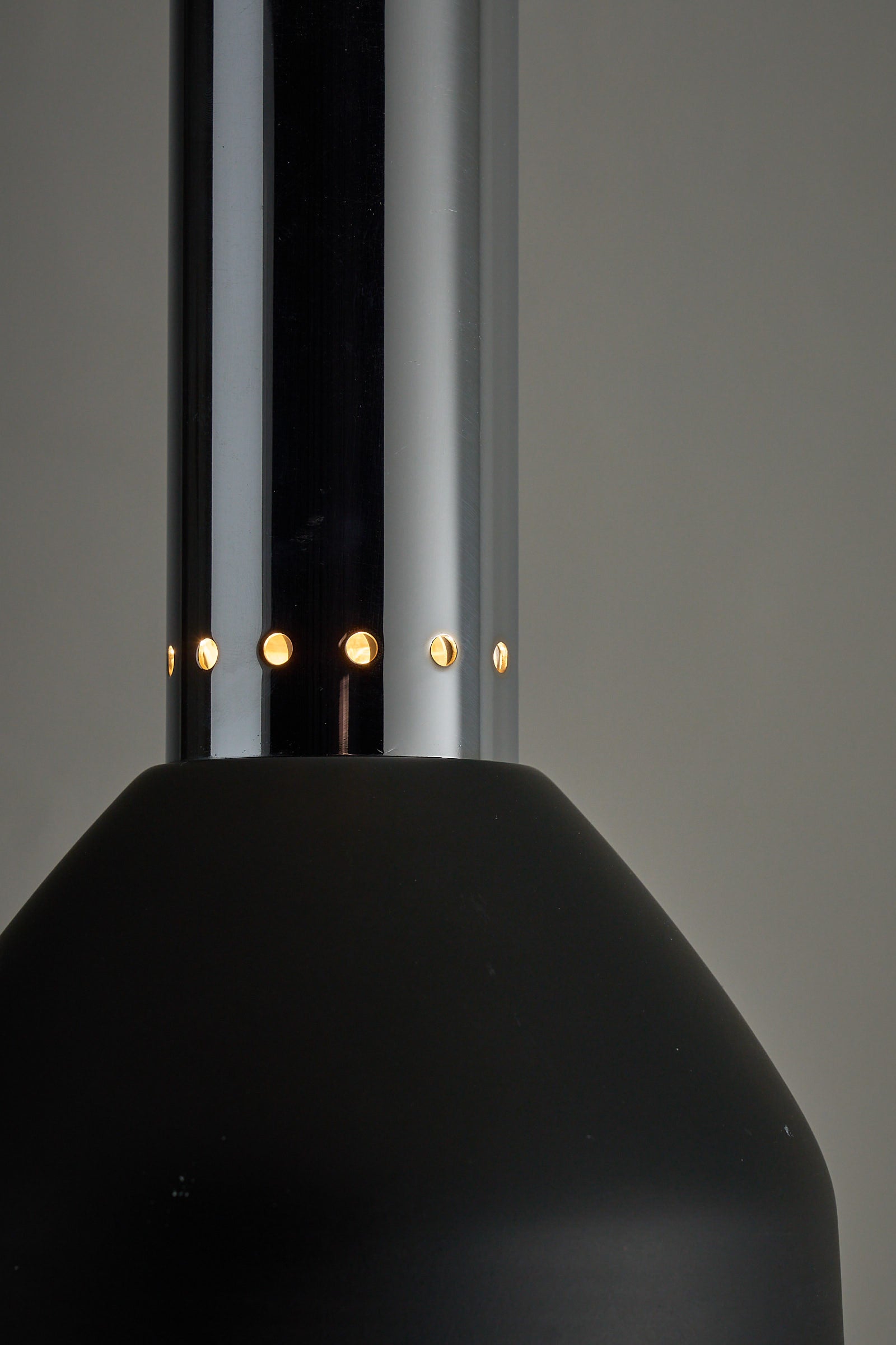 Chrome and Black Pendant Lamp with Perforated Detail showcasing perforations and sleek design for focused lighting.