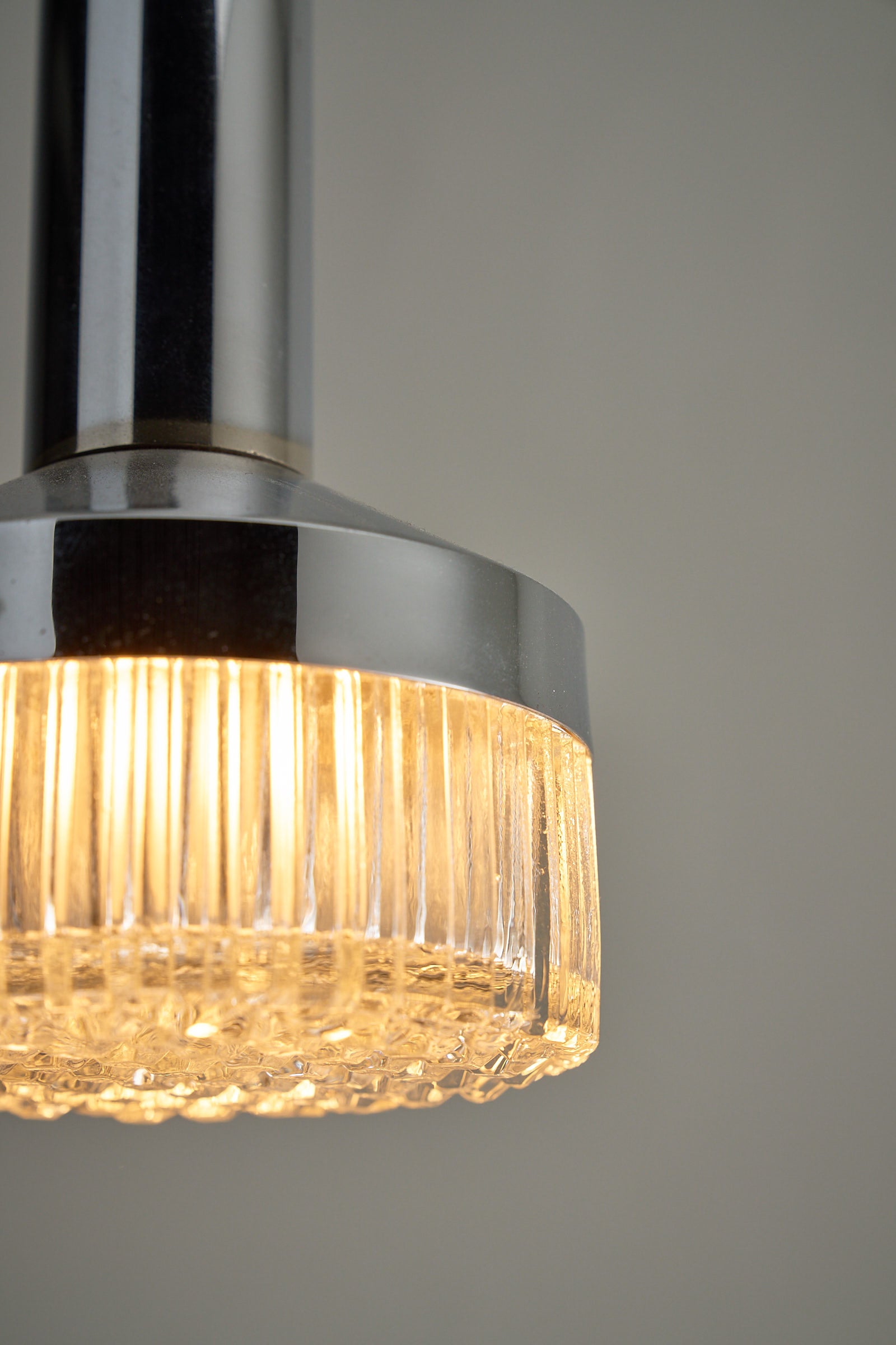 Chrome Pendant Lamp With Textured Glass Diffuser showcasing structured glass, illuminated to create a jewel-like sparkle.