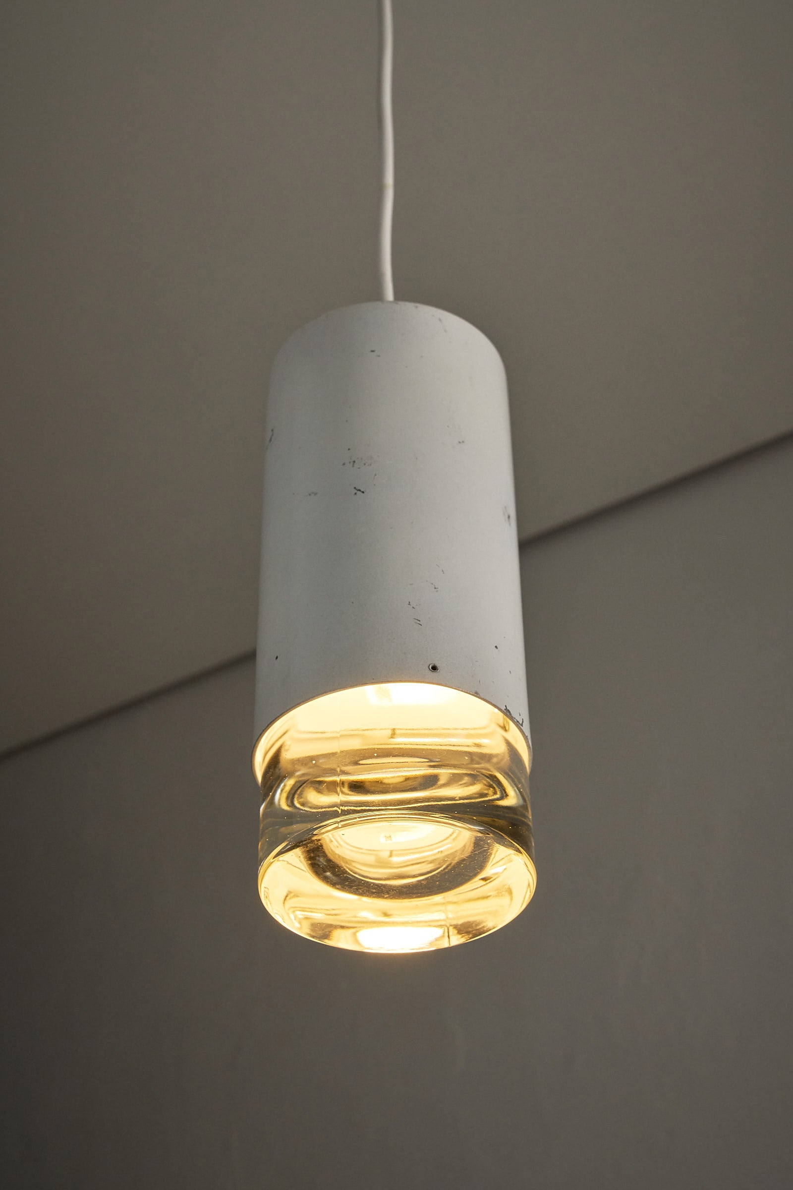 RAAK Amsterdam White Cylinder and Solid Glass Pendant Light showcasing a clean design with a glass diffuser.
