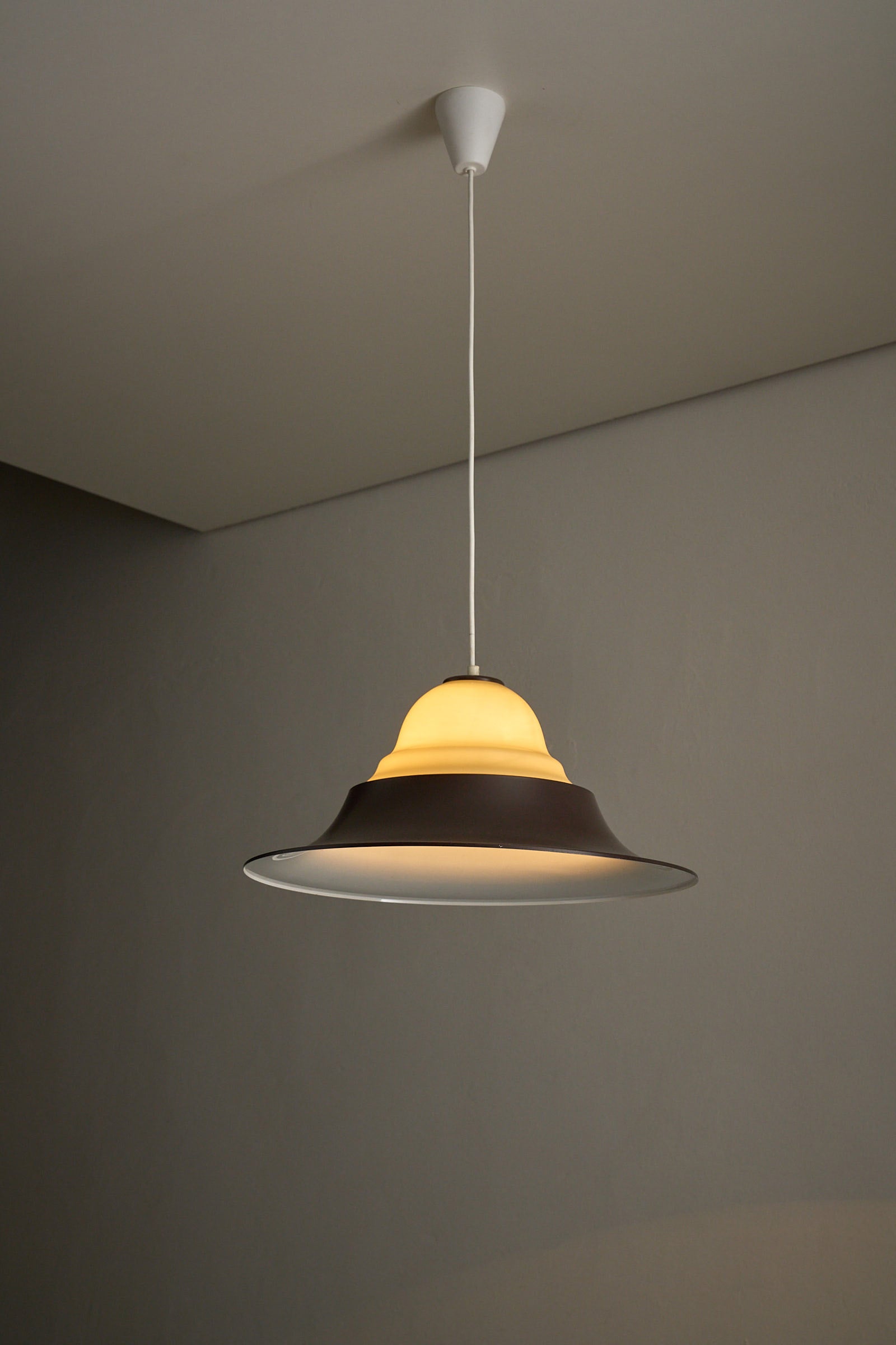 Mid-Century Modern Brown and Opaline Glass Layered Pendant hanging in a modern space, showcasing diffused soft light.