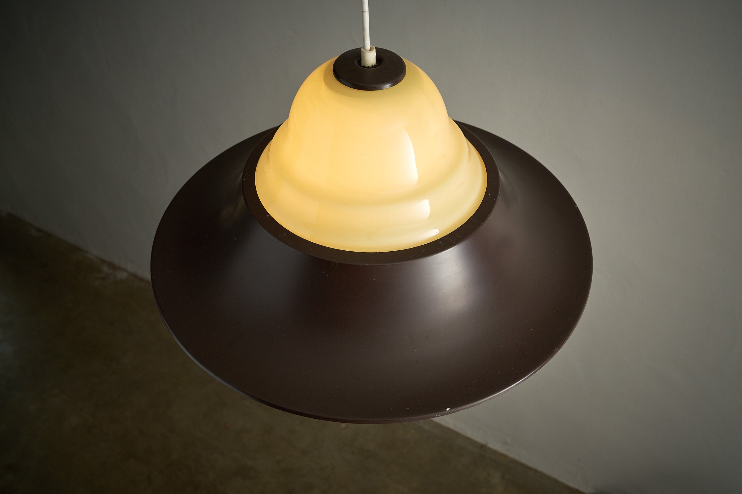 Mid-Century Modern Brown and Opaline Glass Layered Pendant showcasing an amber opaline glass diffuser and dark brown metal shade.