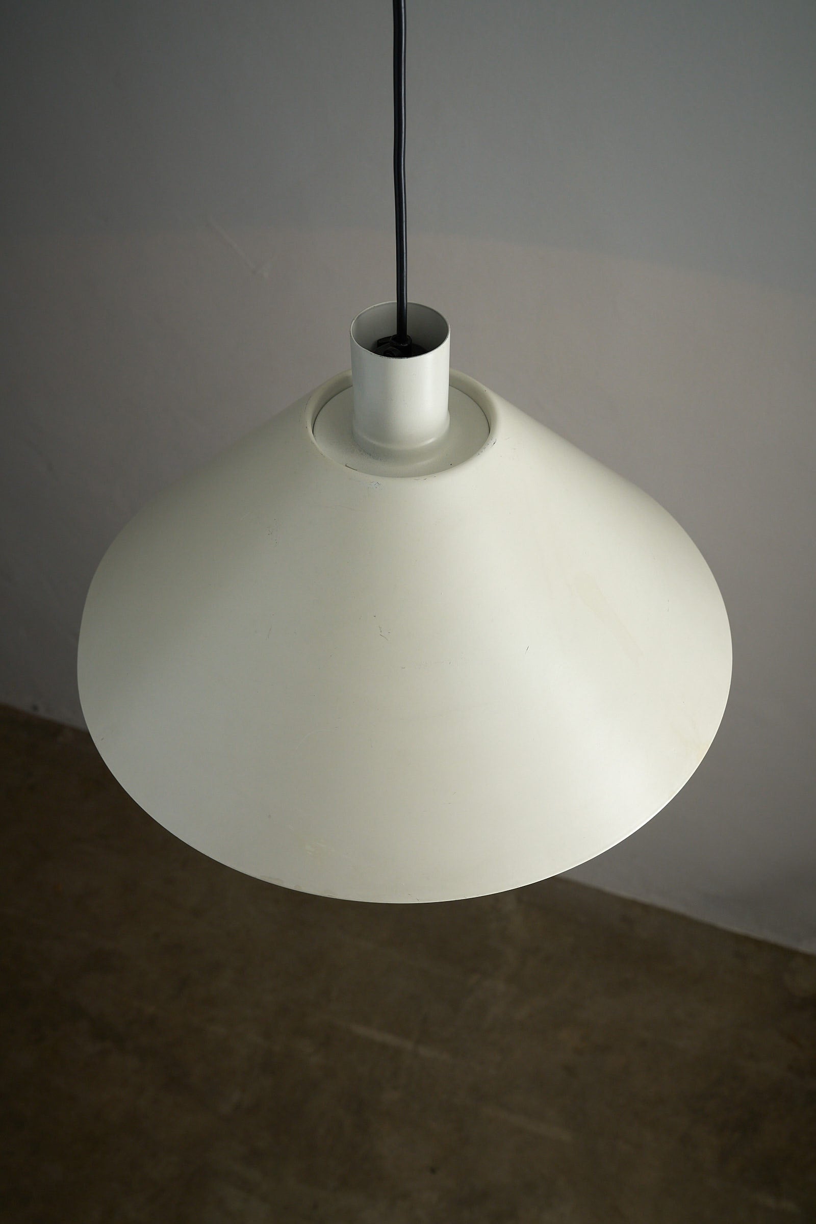 Martinelli Luce Model 1836 Conical Pendant Lamp hanging from the ceiling, showcasing a smooth white exterior.